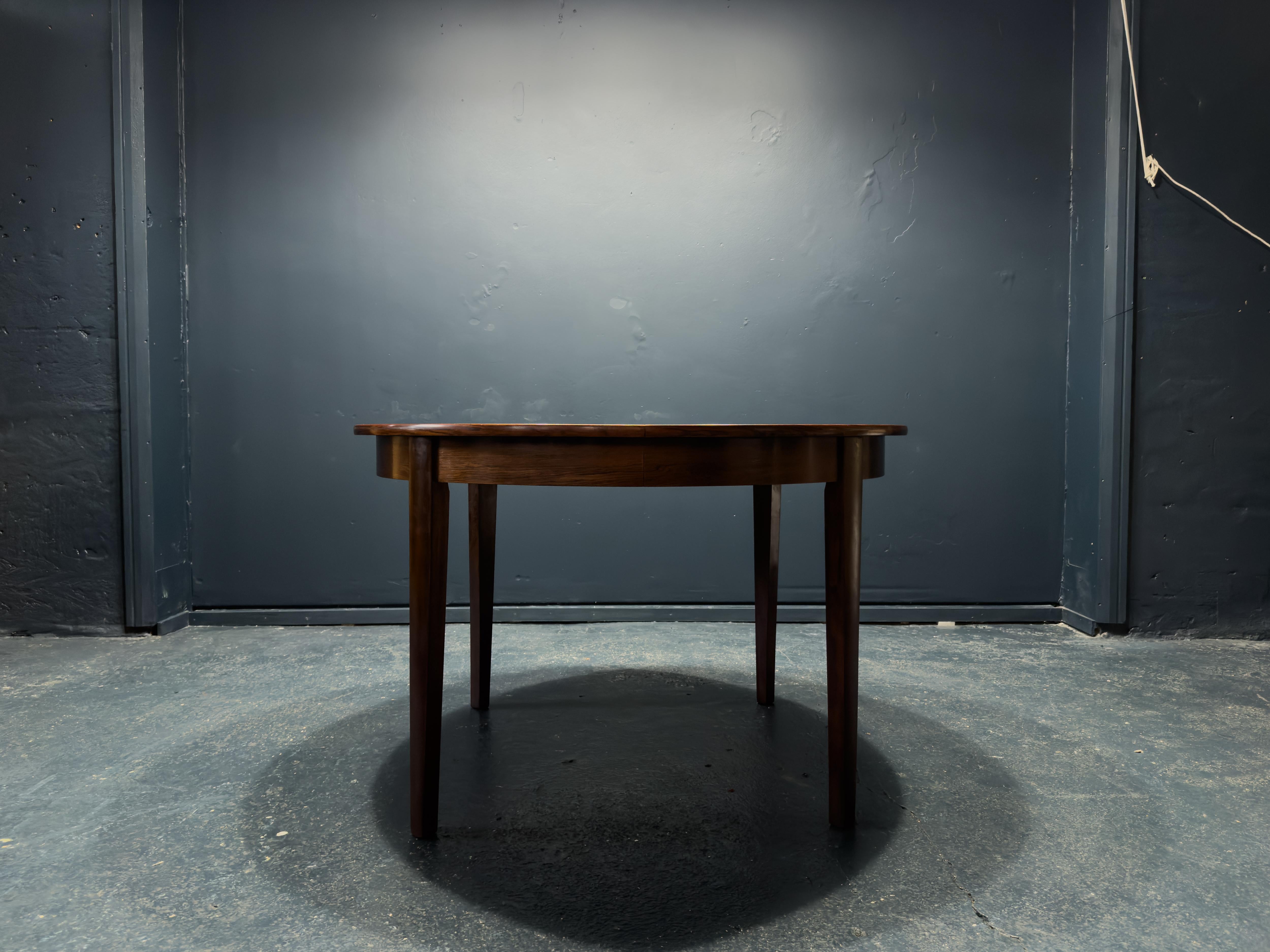 This traditional round hardwood dining table is a wonderful example of classic midcentury design. With fabulous grain and tapered legs, this table can comfortably accommodate four people. The additional three leaves bring the capacity to eight, it
