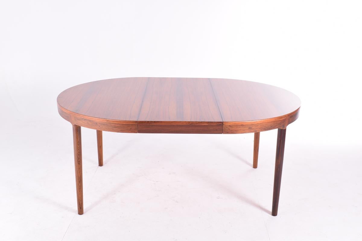 Harry Østergaard dining table for Randers Mobelfabrik, in rosewood with a beautiful veneer. 
The joinery from the legs is very well designed and crafted, fitting exceptionally on the skirt of the table. 
Two leaves available one with skirt, one