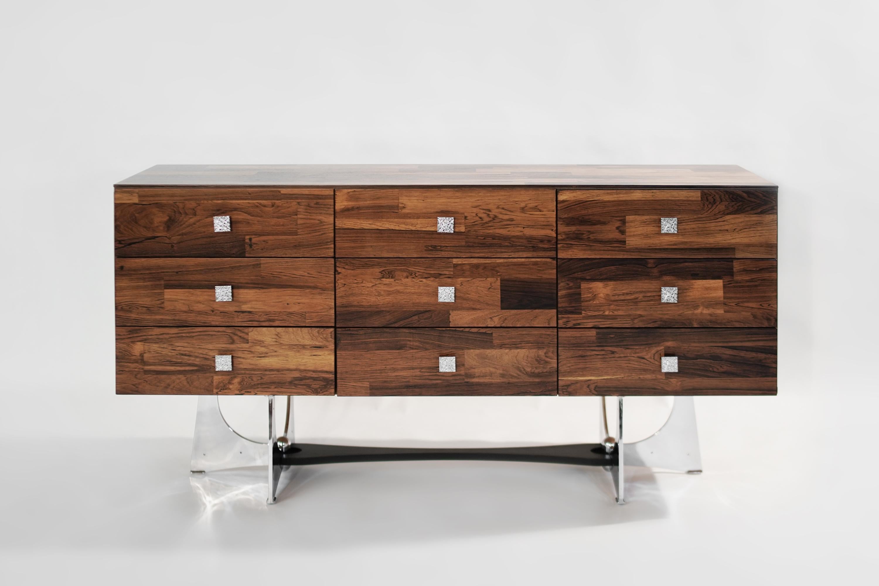 Rosewood dresser designed by Henri Valliere, Canada, 1950s.
This case piece features, brutalist style nickel base and hardware. A total of 9 drawers provides ample storage space for either dining room or bedroom setting.