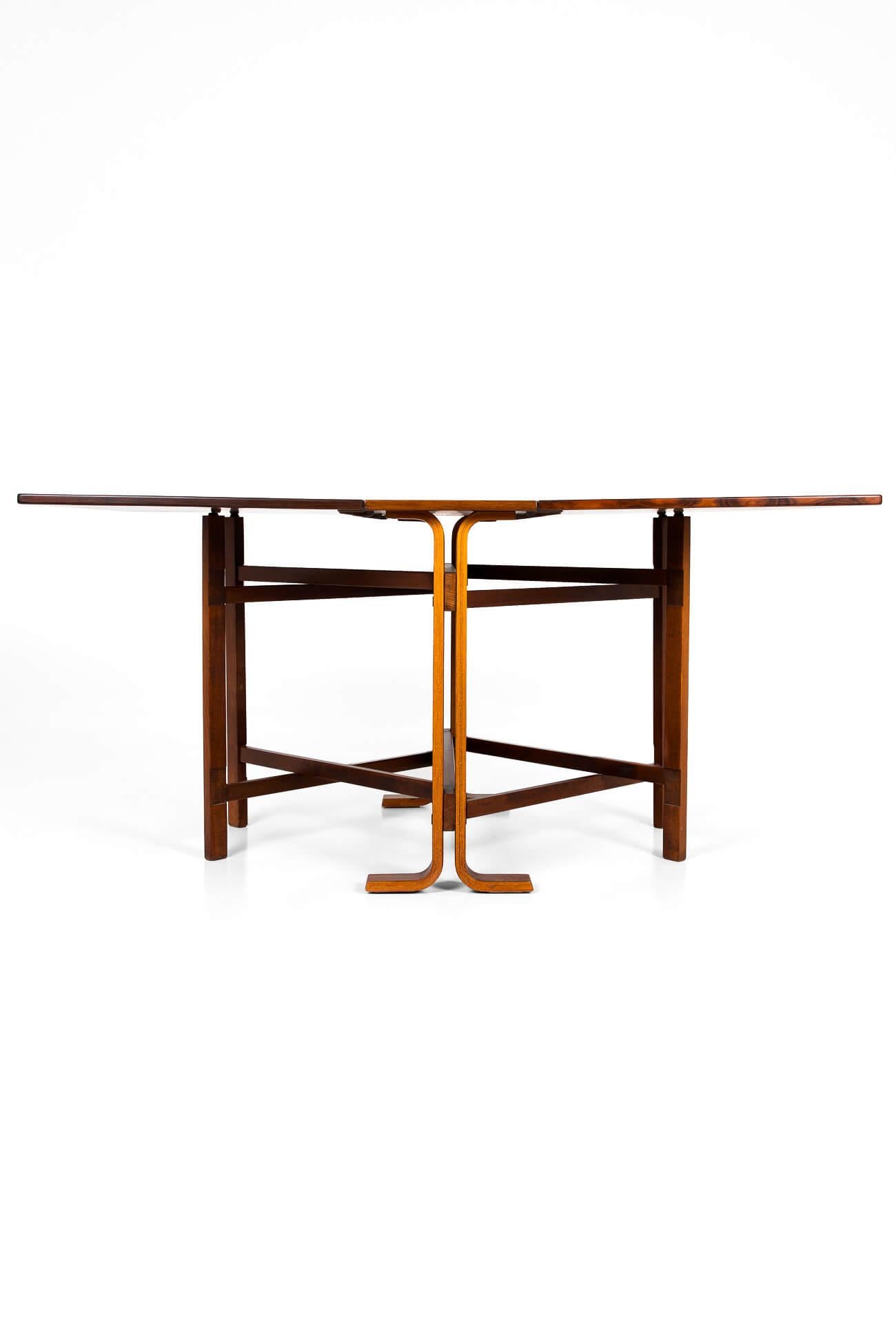 Classic mid-century drop-leaf dining table by Bendt Winge for Kleppe Møbelfabrik of Norway. With wonderful clean lines, this is the rarer version of Model 4 by Bendt Winge with a rosewood top and teak base. In immaculate condition, the table leaves