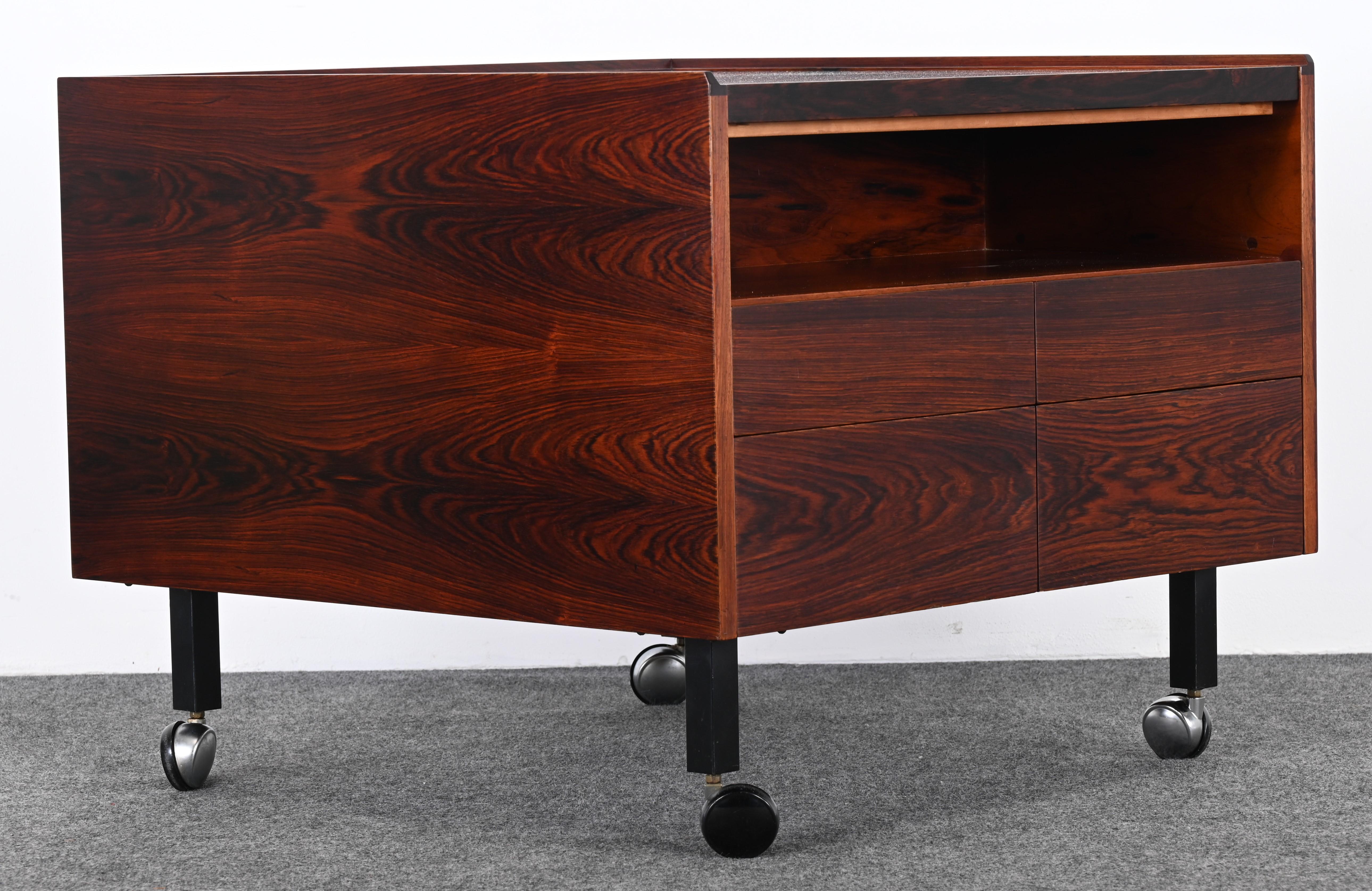 A gorgeous rosewood dry bar attributed to Arne Vodder for Sibast, 1950s. This cabinet is a wonderful size for an apartment or Mid-Century Modern home. It would work well in a traditional setting and is very versatile having four sliding drawers. The