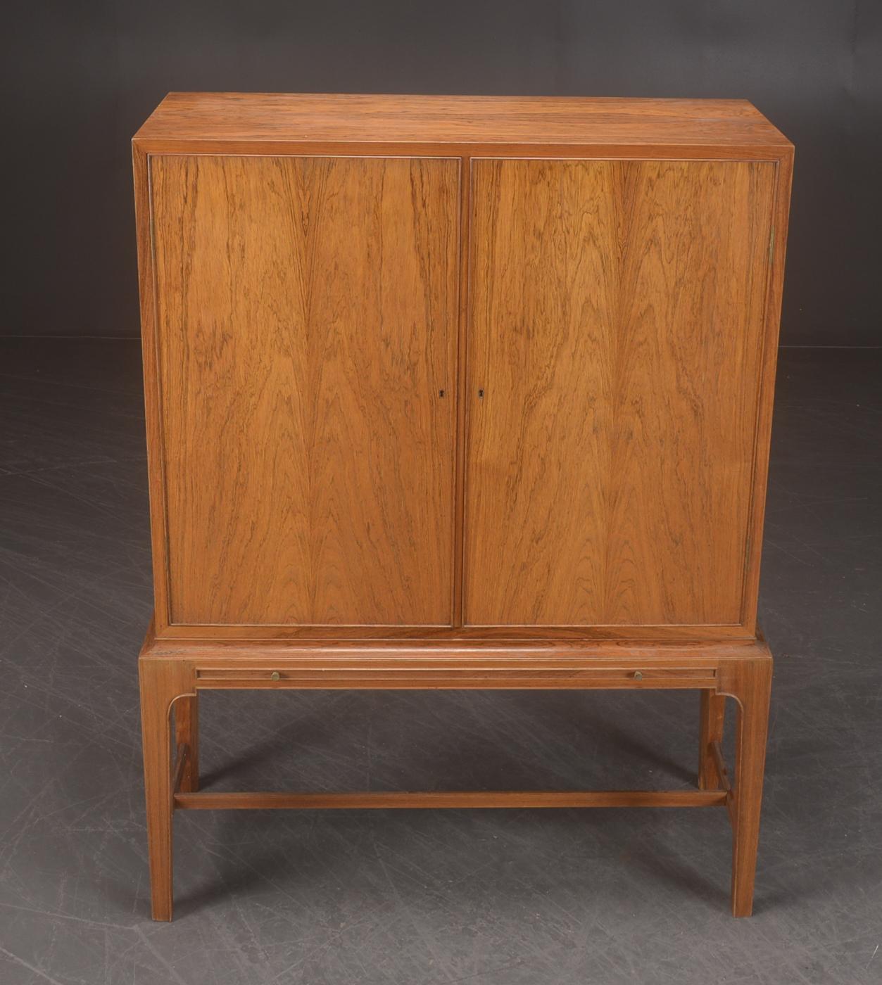 Danish rosewood dry bar cabinet, manufactured by C.B. Hansen in style of Kaare Klint.
Right side has two glass shelves. Back wall and sides are made off small square mirrors.
Left side has 3 shelves and 2 drawers.

Cabinet doors have unique