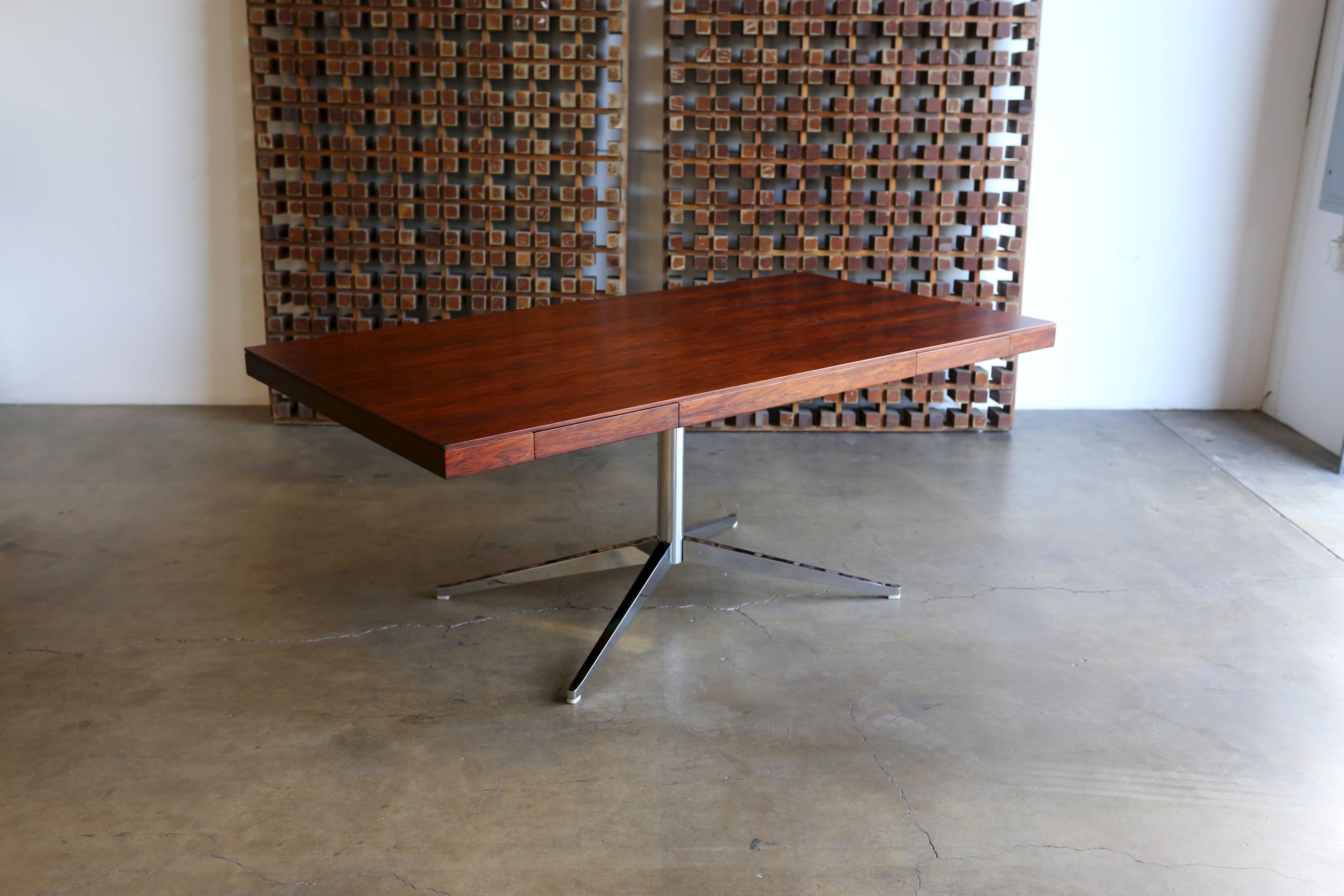Rosewood executive partners desk by Florence Knoll. Manufactured by Knoll. Highly figured rosewood grain with a mirror polished nickel-plated base. Drawers on both sides. This piece has been professionally restored.