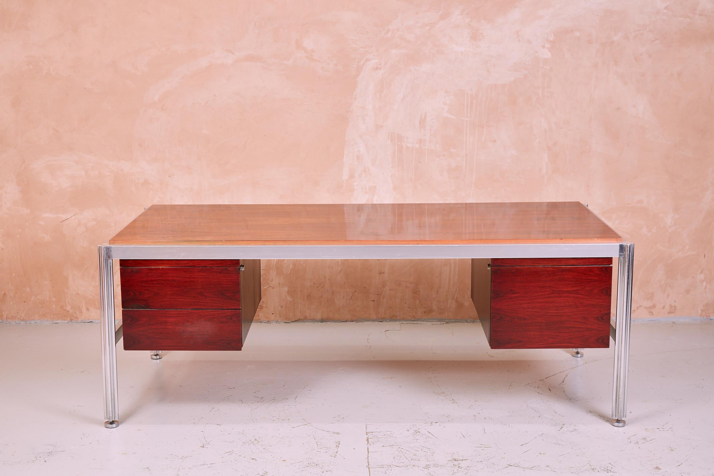 Designed by the Italian George Ciancimino and produced by French manufacturer Mobilier International in the 1970s. The desk is an impressive executive piece. A broad, gloss lacquered, rosewood top sits in an aluminium frame with ornate quatrefoil