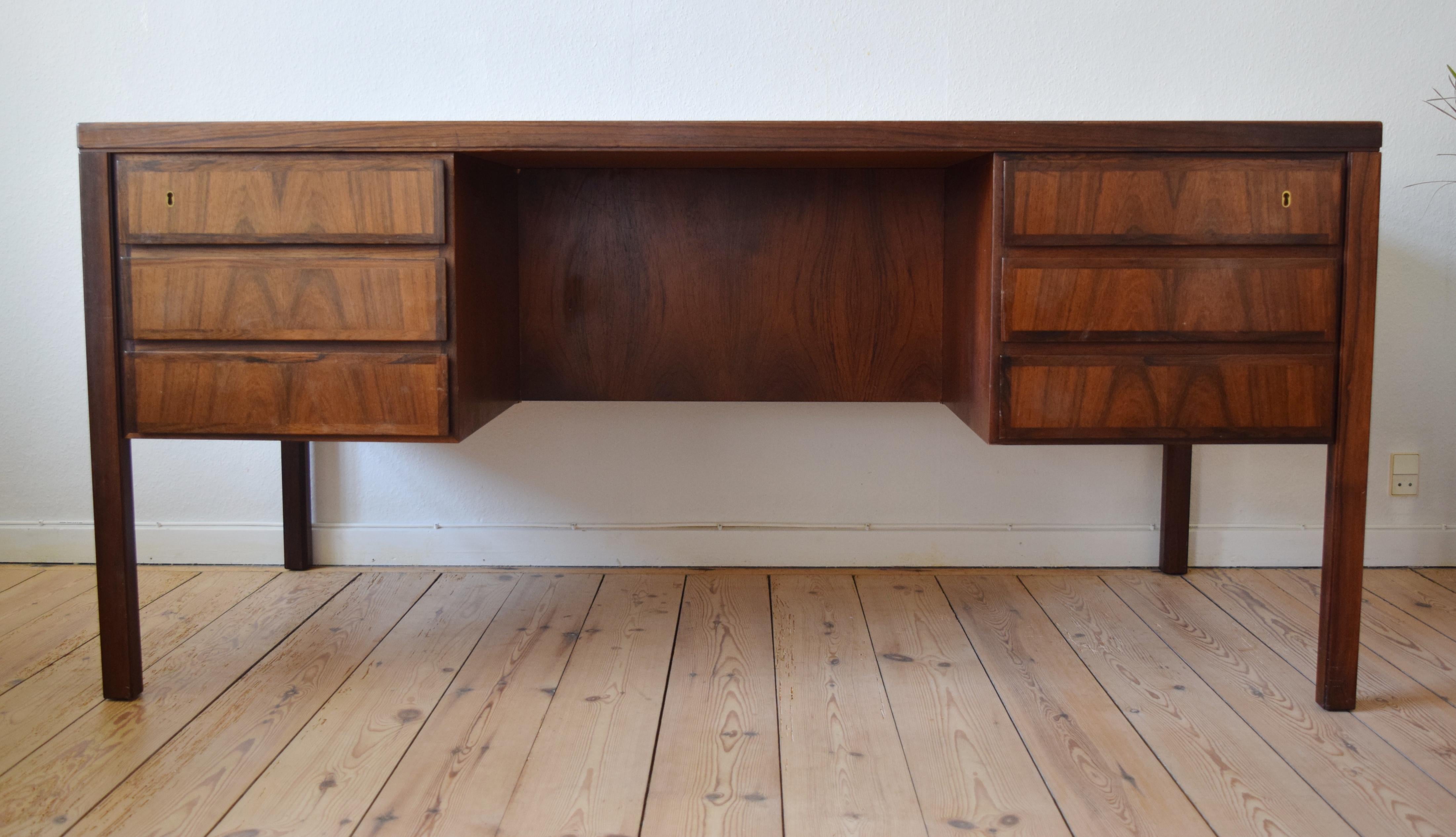 Large executive model 77 desk designed by Gunni Omann for Omann Jun Møbelfabrik, Denmark in the 1960s. This desk features six drawers (lockable) with bevelled edges and solid rosewood fronts with matched grain. On the rear are two compartments for