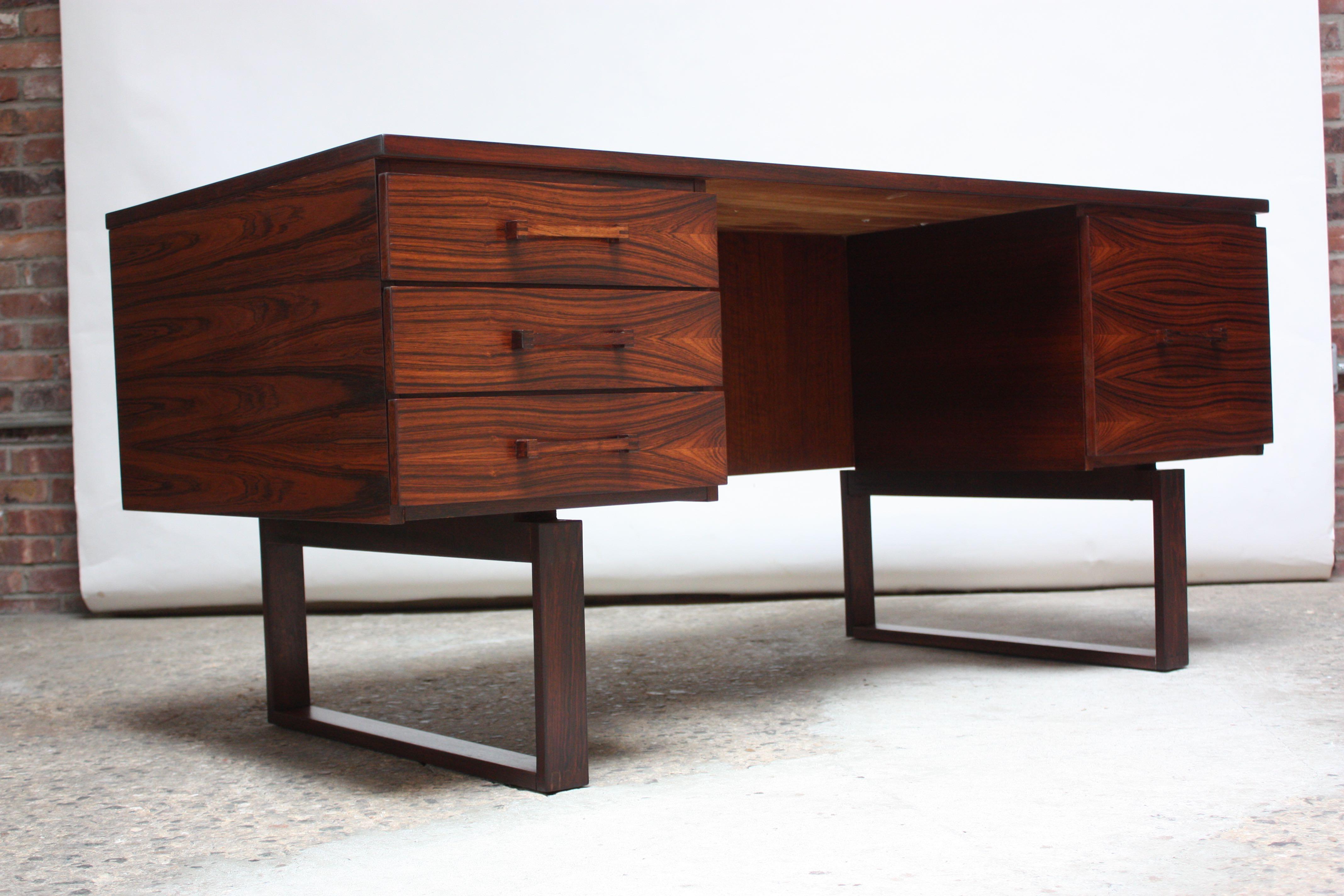 Henning Jensen and Torben Valeur rosewood desk for Dyrlund. Unique details include two carved rectangular bases which give the desk itself a floating, light-weight appearance. Ample storage with three drawers and a separate filing cabinet