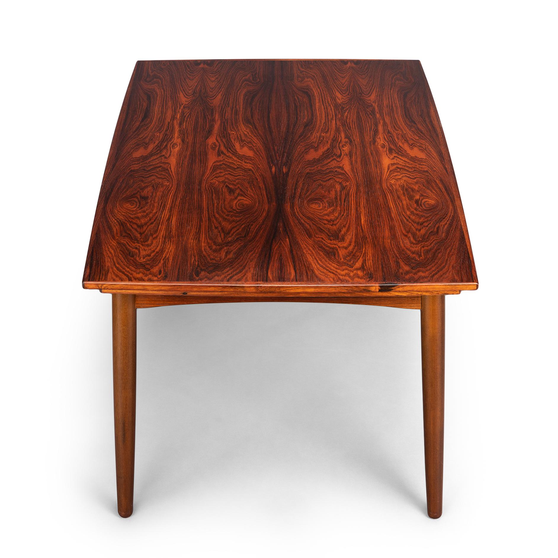 Marvelous dining table crafted in a stunning mahogany veneer and solid mahogany. Design by Kai Kristiansen for FM Møbler and produced in the early 1960s. Very high degree of quality brought into play with a slight oval shape that extends further