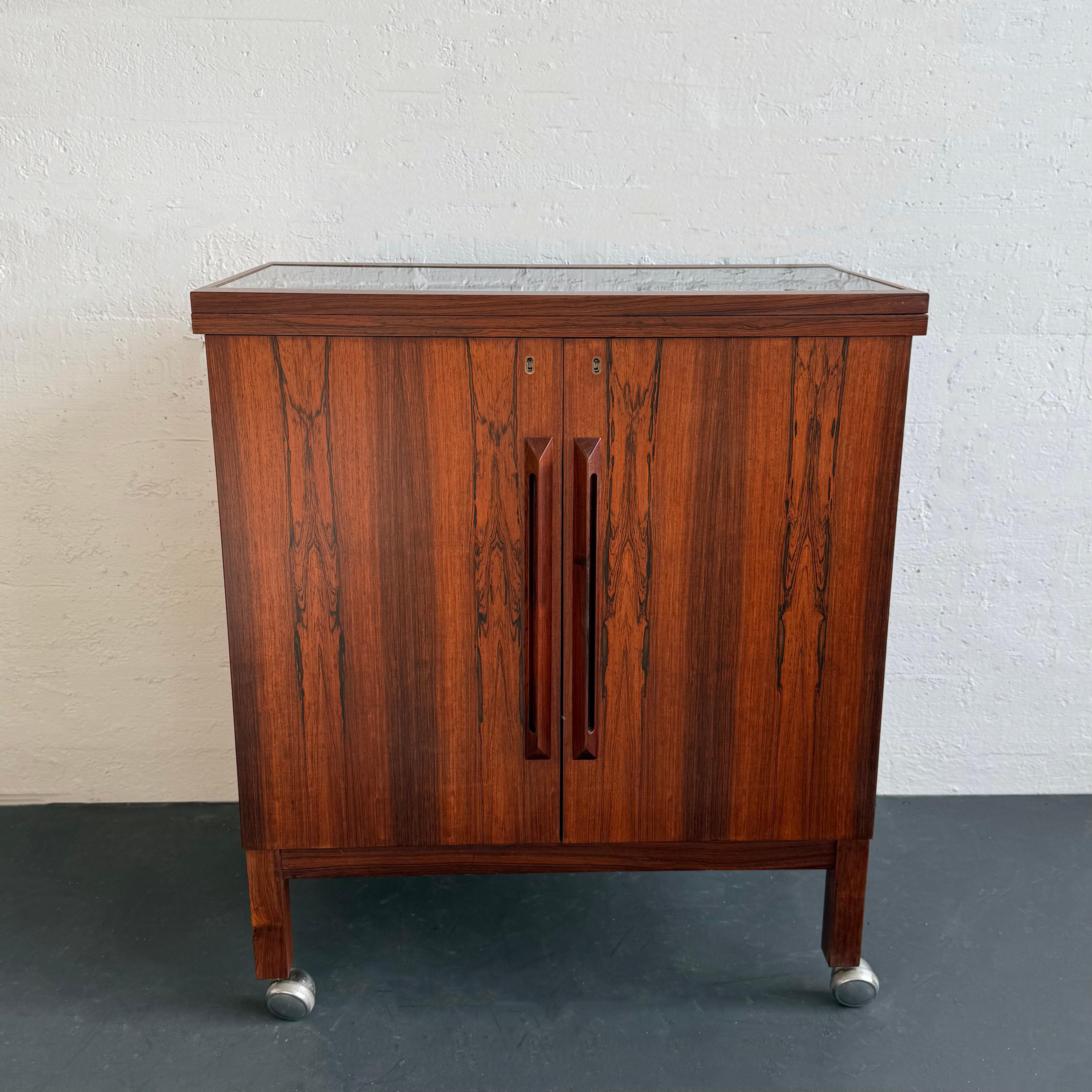 Este impresionante mueble bar rodante y extensible de estilo moderno escandinavo fue diseñado por el destacado diseñador noruego Torbjørn Afdal para la empresa Bruksbo, de la que era diseñador jefe. La carrera de Afdal despegó cuando sus muebles