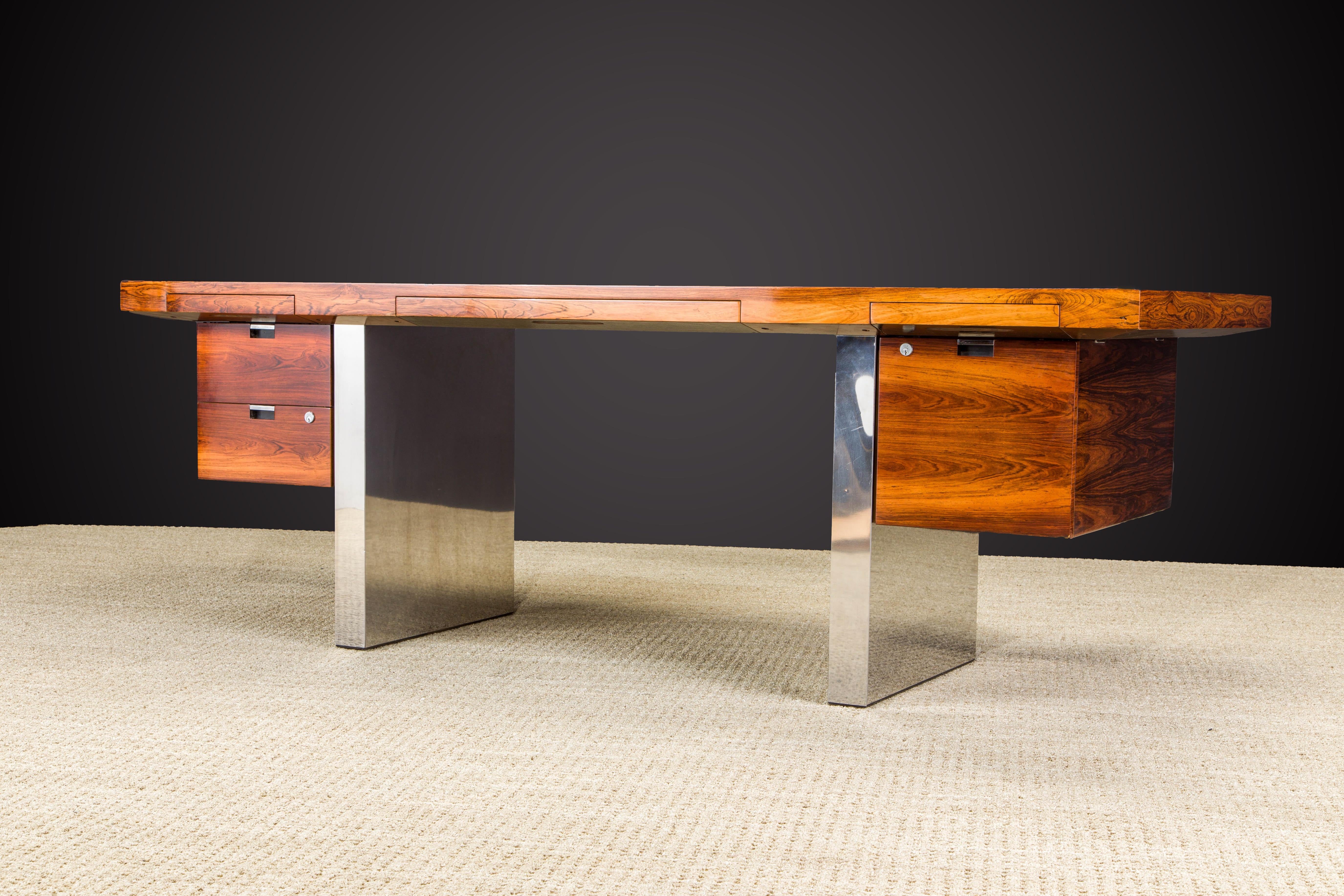 This grand executive desk by Roger Sprunger for Dunbar features a beautifully refinished Rosewood floating top and drawers with a pair of signature chrome paneled legs, designed and made in the 1970s. Signed with Dunbar tag as can be seen in photos.