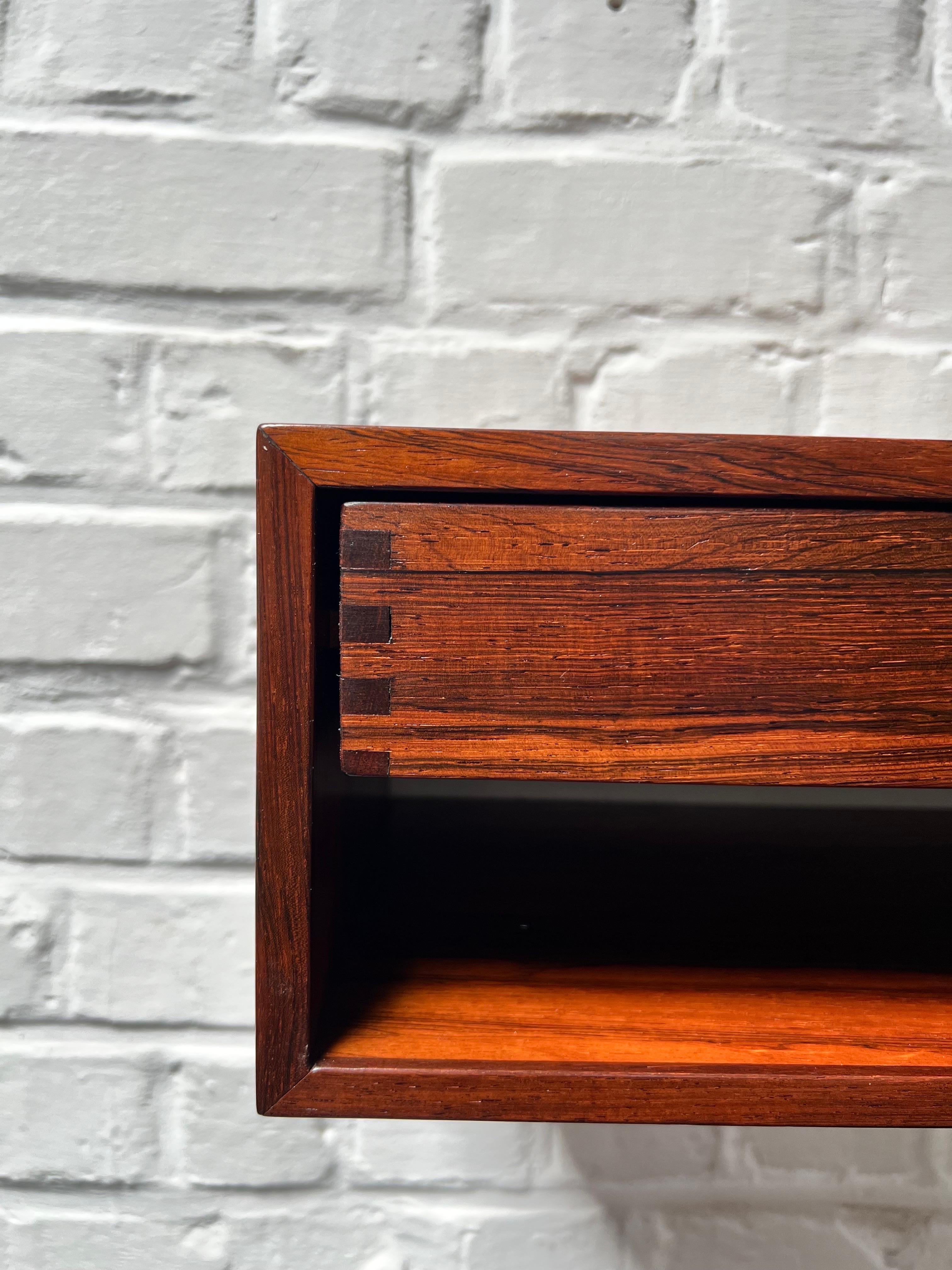 This is a elegant floating console/ nightstand. The model is extremely rare and rarely offered in rosewood. Made of the finest veneer. The drawer is made of massive rosewood and the joinery on the sides offer a nice pattern. Perfect as nightstands