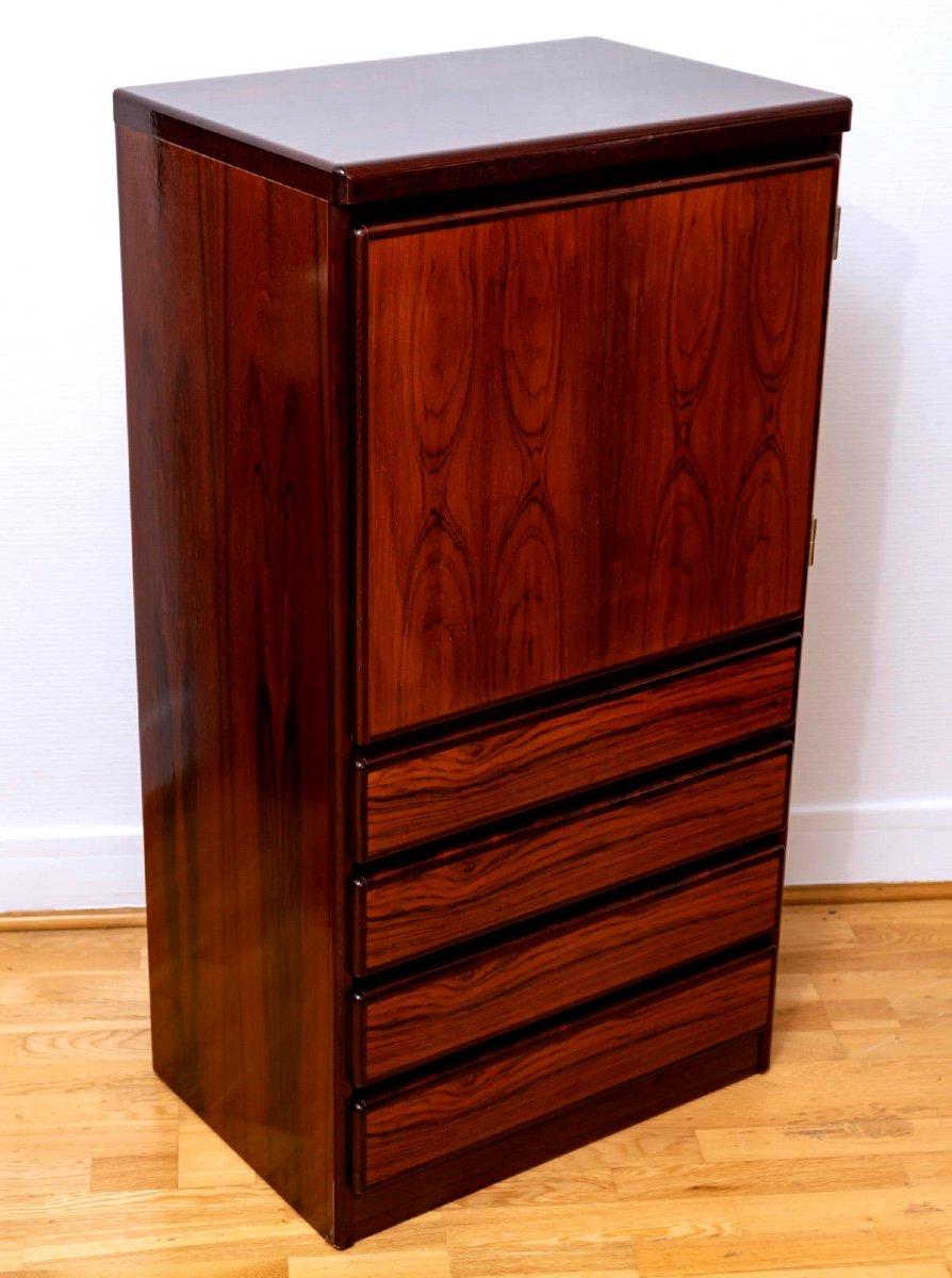 Delightful rosewood set from DYRLUND, Denmark, comprising a four-drawer chest topped by a pedestal with adjustable shelves and a door that closes with a flap.
With its slimline format, this compact piece of furniture has plenty of storage space and