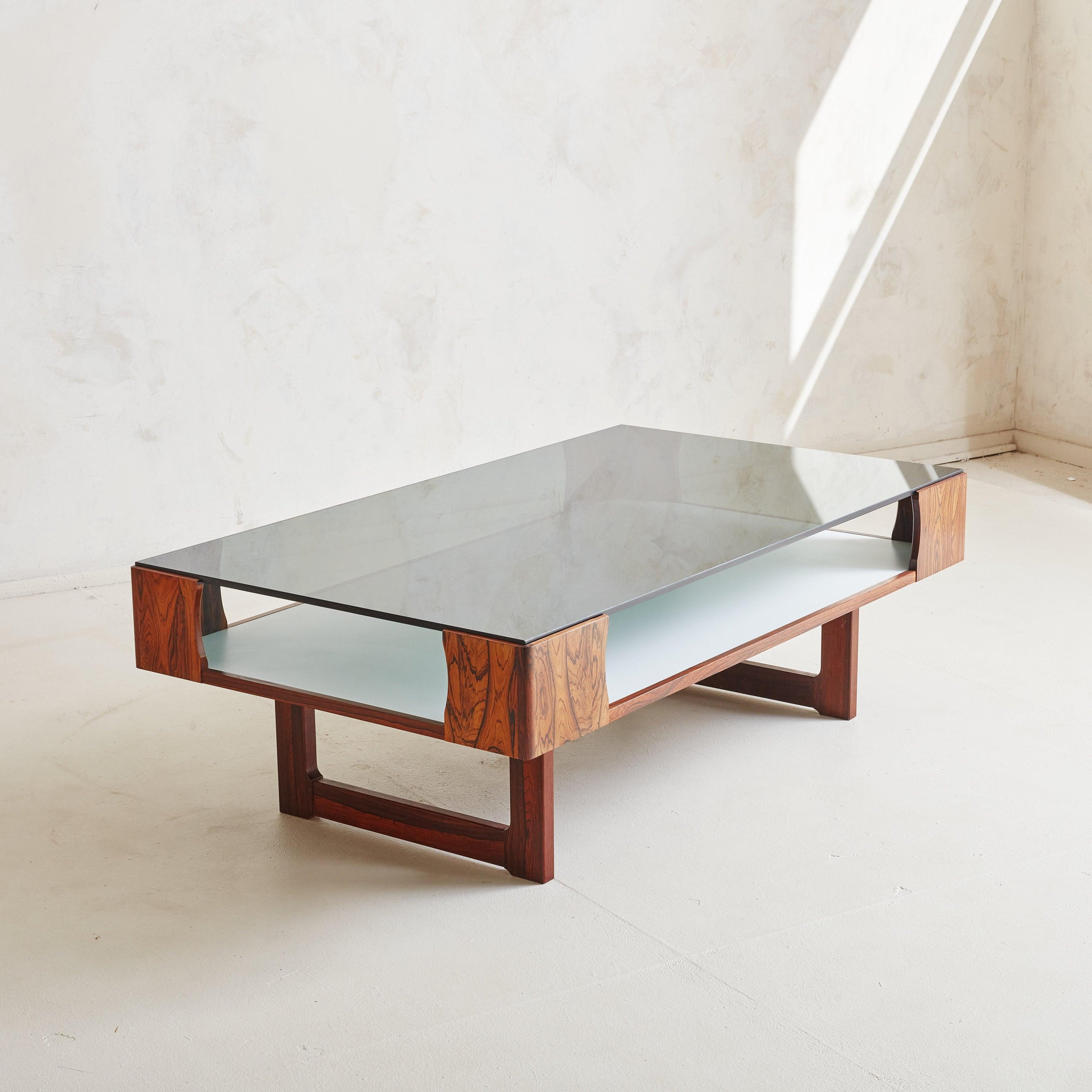 A gorgeous 1970s Scandinavian Modern two-tier coffee table designed by Torbjörn Afdal for Bruksbo in Norway. This coffee table features a beautifully crafted rectangular rosewood frame that highlights the wood's rich grain and warm tone. The design