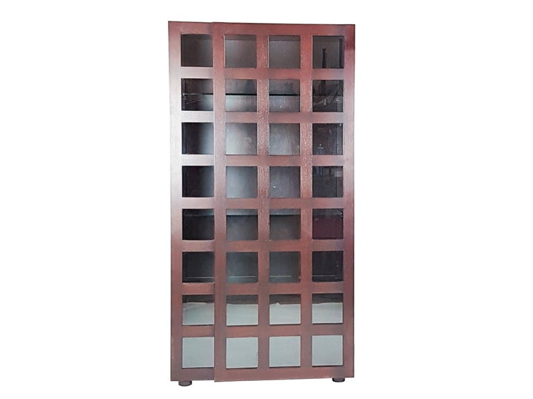 This bookcase or vitrine cabinet is made from a wooden structure with a grid design front side. It features a unique door with a magnetic closure and 4 thick glass shelves. The bookcase remains in excellent condition: just one small repair as stated