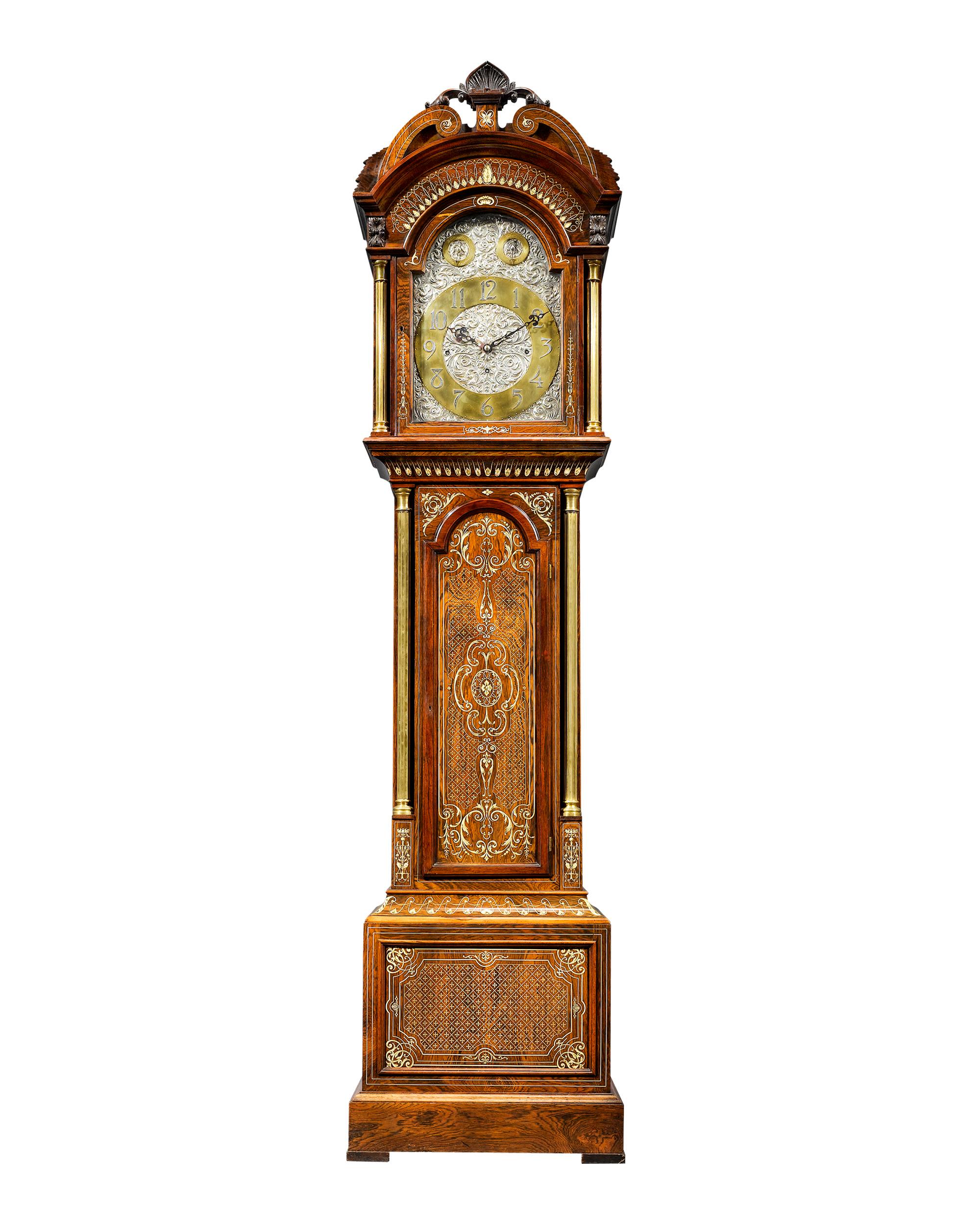 This magnificent English longcase, or grandfather, clock boasts a fine rosewood case inlaid with an intricate, balanced design. The face is crafted of chased silver in a foliate motif with fully hallmarked numerals by London silversmith James