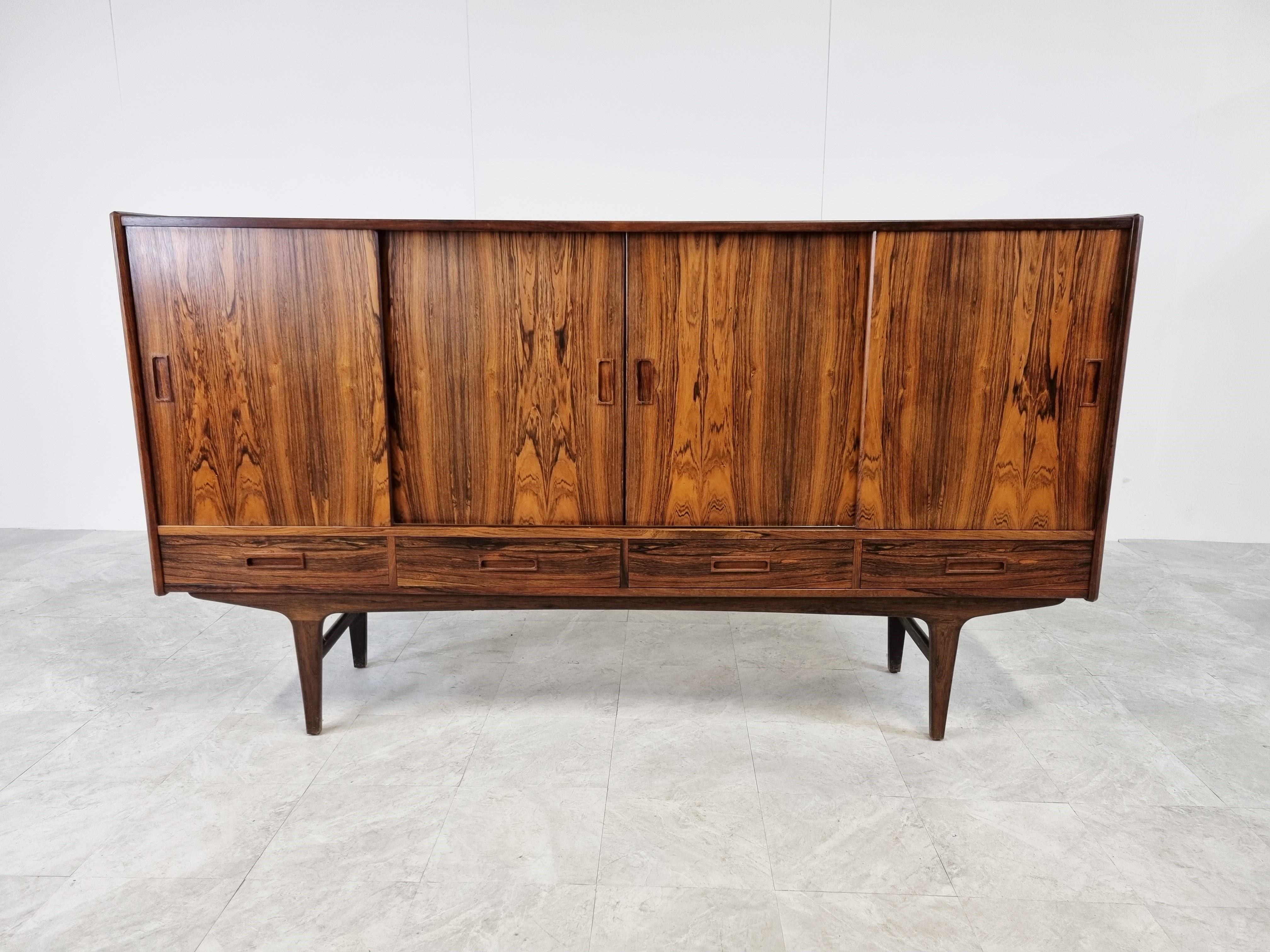 Striking mid century rosewood highboard designed by Borge Seindal for P. Westergaard Mobelfabrik.

The highboard has beautiful wood vaining.

It has 4 sliding doors and 4 drawers providing plenty of storage space.

It also has 3 drawers