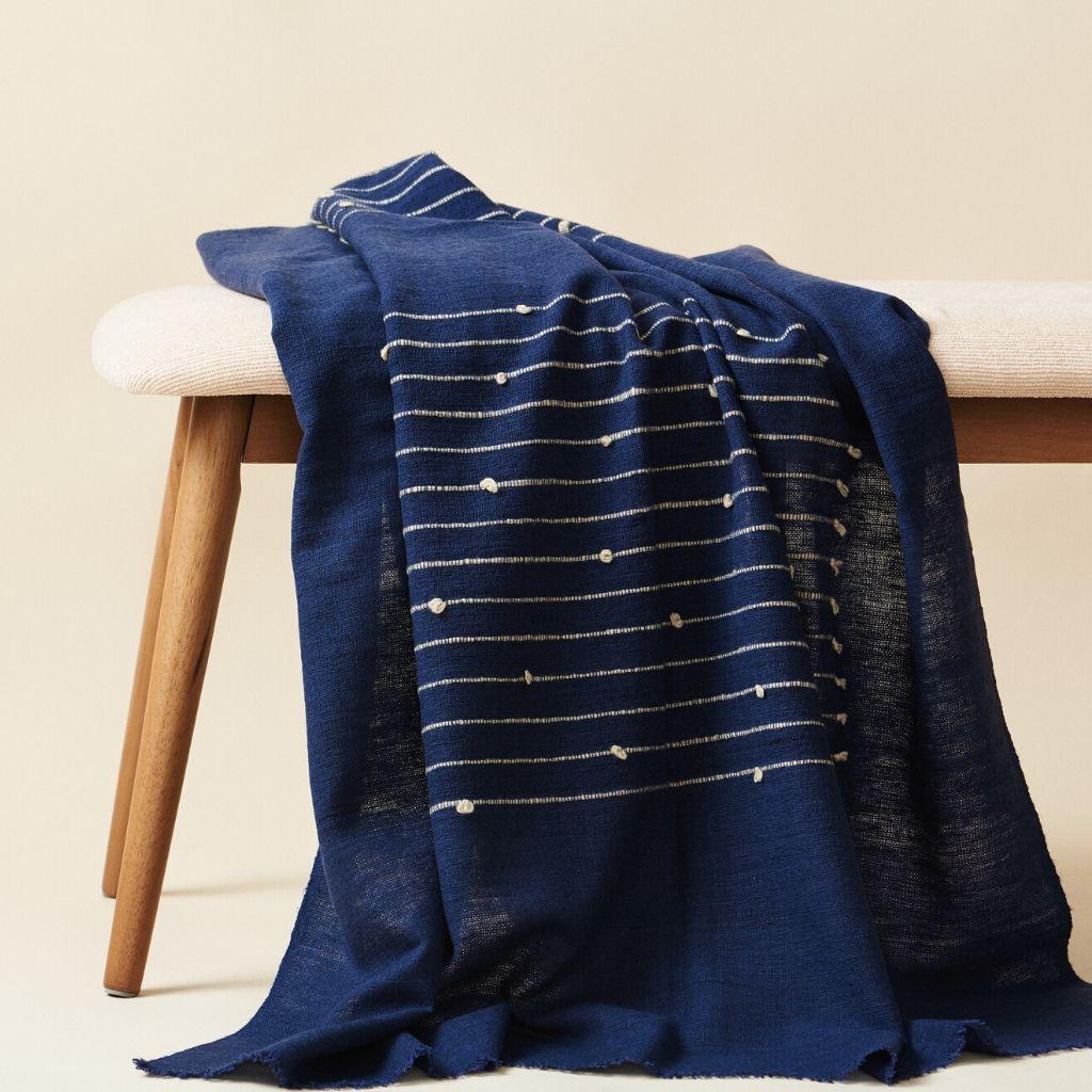 Custom design by Studio Variously, Rosewood Indigo merino Queen Size bedspread / coverlet is hand-woven by master weavers in Nepal and dyed entirely with eco-friendly dyes. 

A sustainable design brand based out of Michigan, Studio Variously
