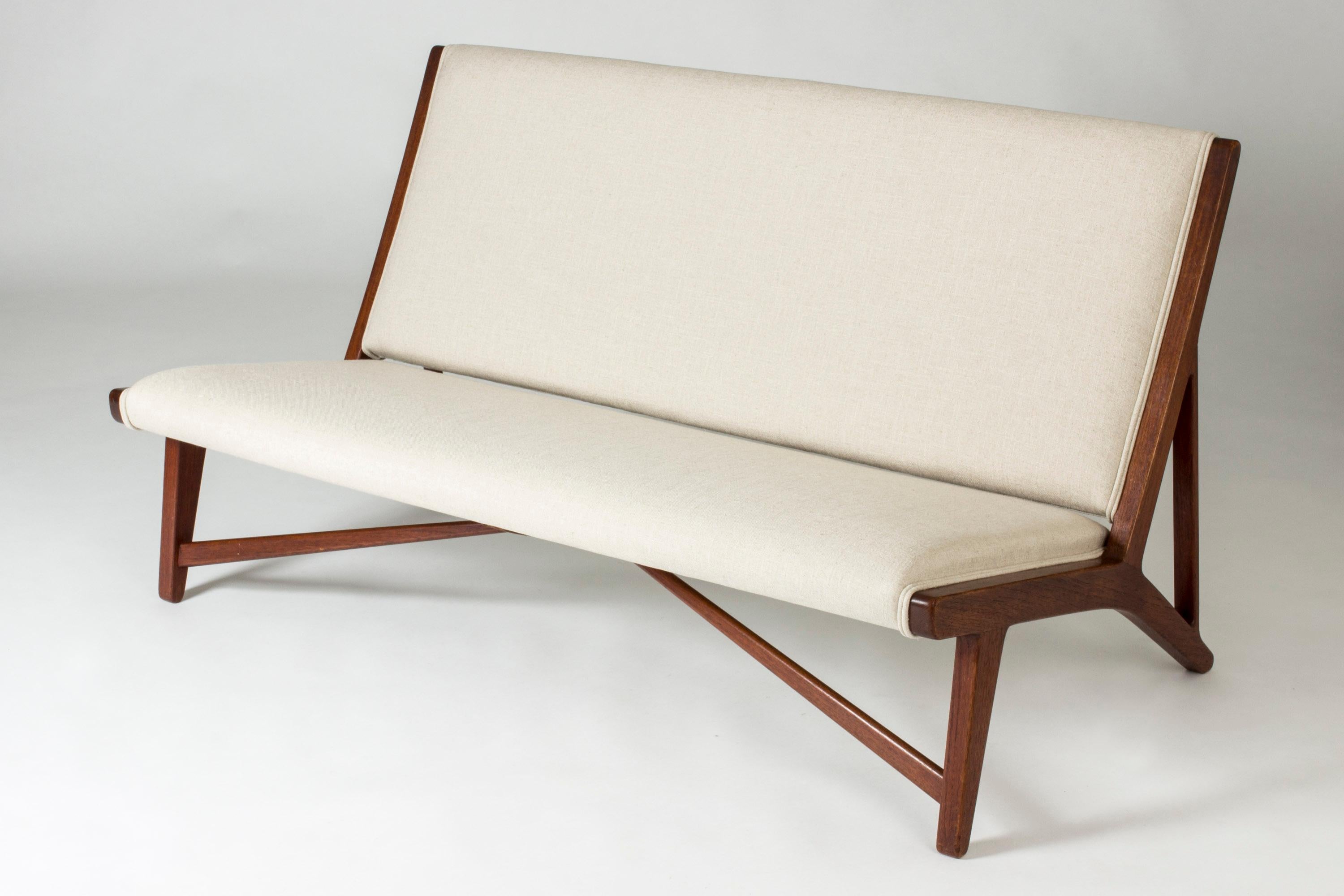 Amazing sofa by Hans J. Wegner, model “JH 555”. Made from teak with linen upholstery. Clean lines with a striking silhouette and decorative wooden elements. Casually elegant, laid-back design.