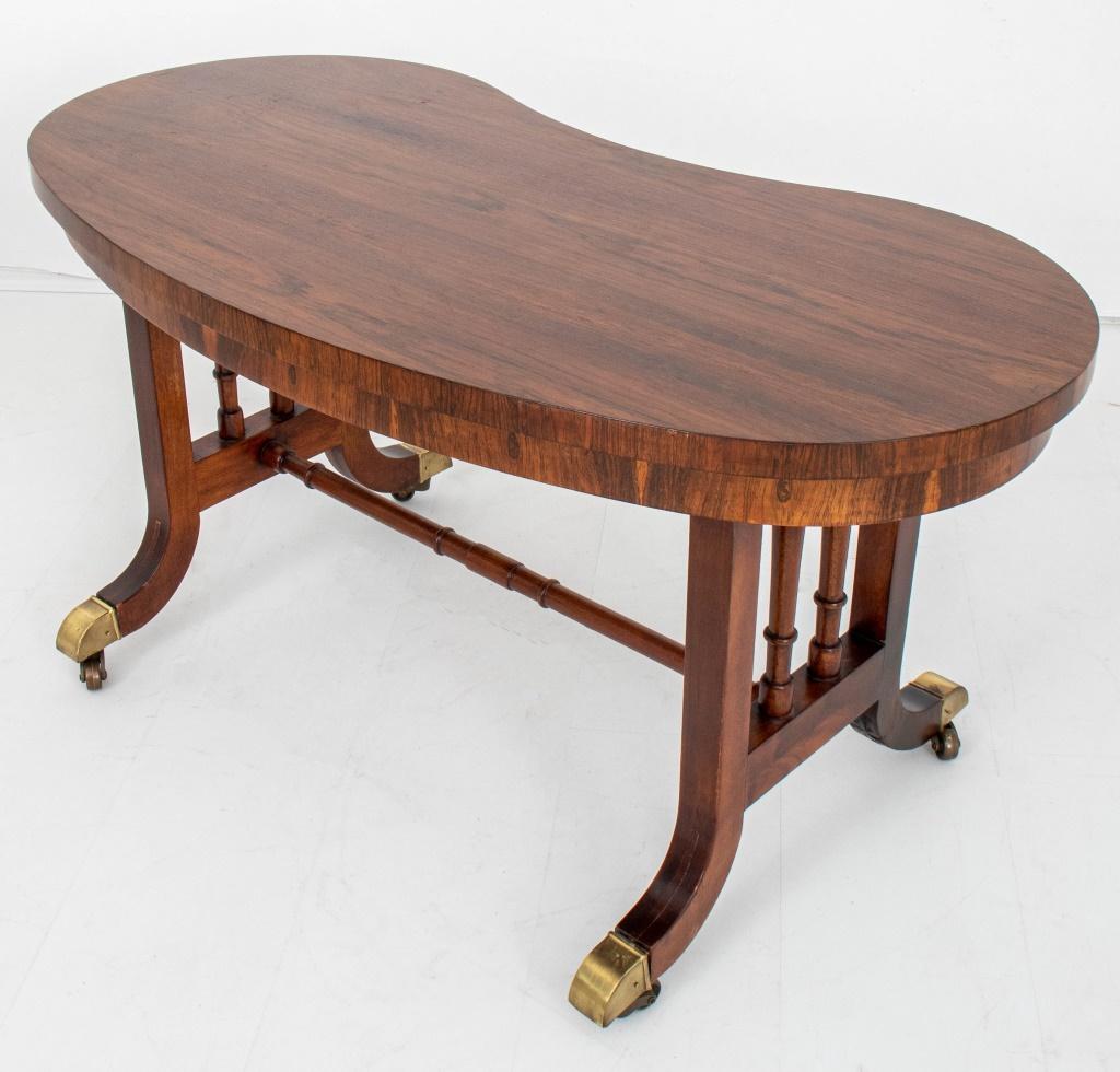 Rosewood kidney shaped low table, the shaped top above two spindled supports conjoined by a stretcher above splay feet on casters.

Dealer: S138XX