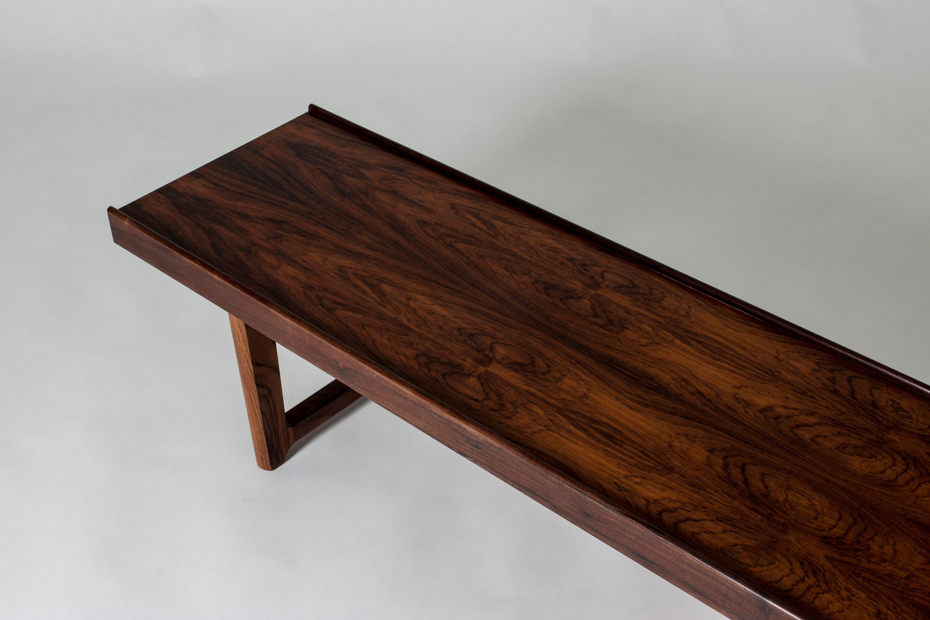 Sleek rosewood “Krobo” bench by Torbjørn Afdal, with black metal extenders underneath. Beautiful, saturated brown veneer. Great as a coffee table or room divider.