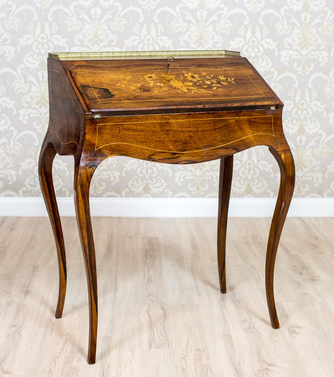 A piece of furniture, circa 1920-1930, of oaken framework in rosewood veneer.
The apron with adjustable desktop, supported on neat, bentwood legs.
The sides and the front are decorated with filet stripes. The desktop is intarsiated with a floral