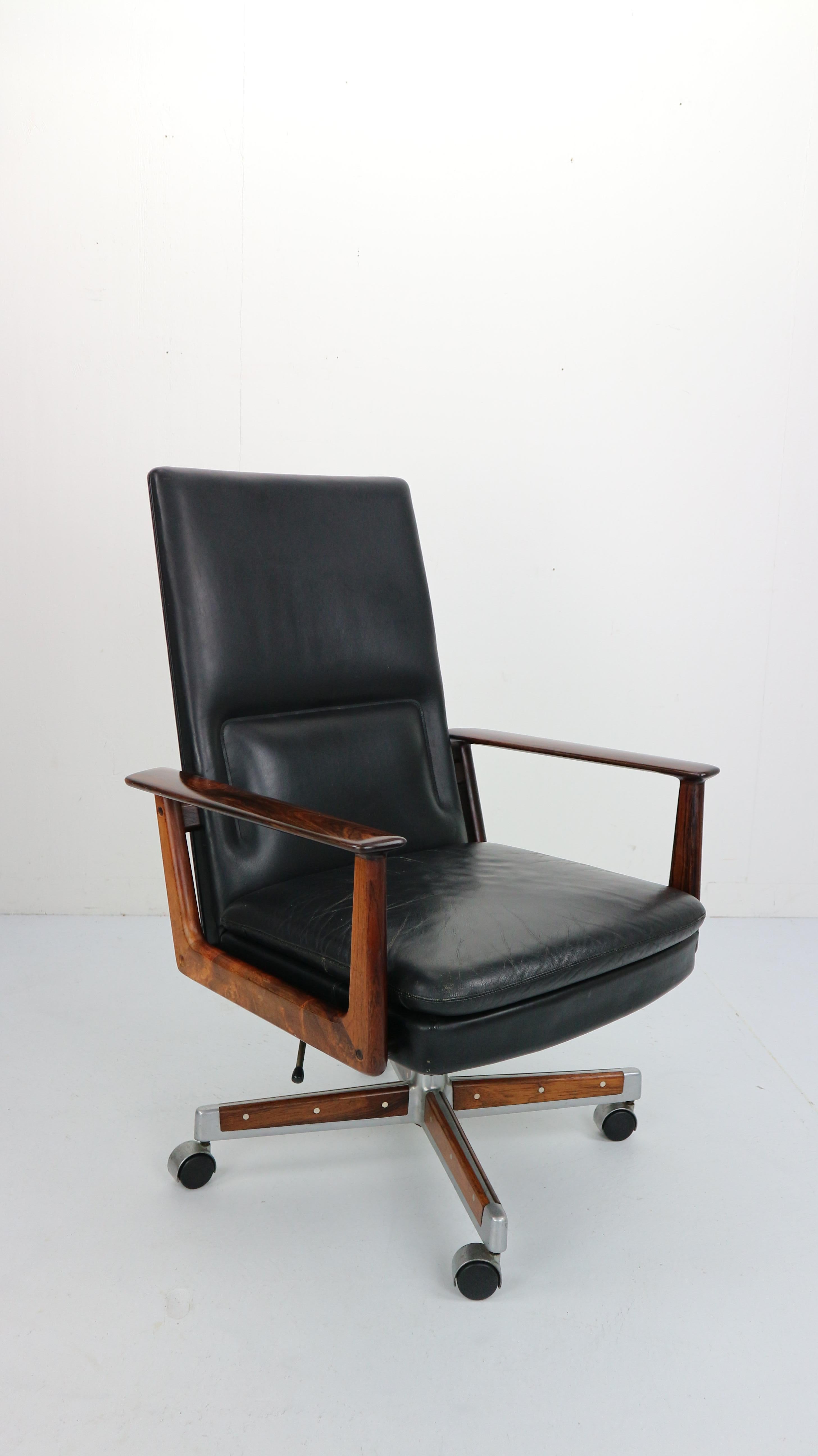 President desk chair model- 419 designed by Arne Vodder and manufactured by Sibast Mobler, Denmark, 1960.
This Danish design exclusive chair has sculptured rosewood armrests, the aluminum base with rosewood inlay and the black leather seating makes