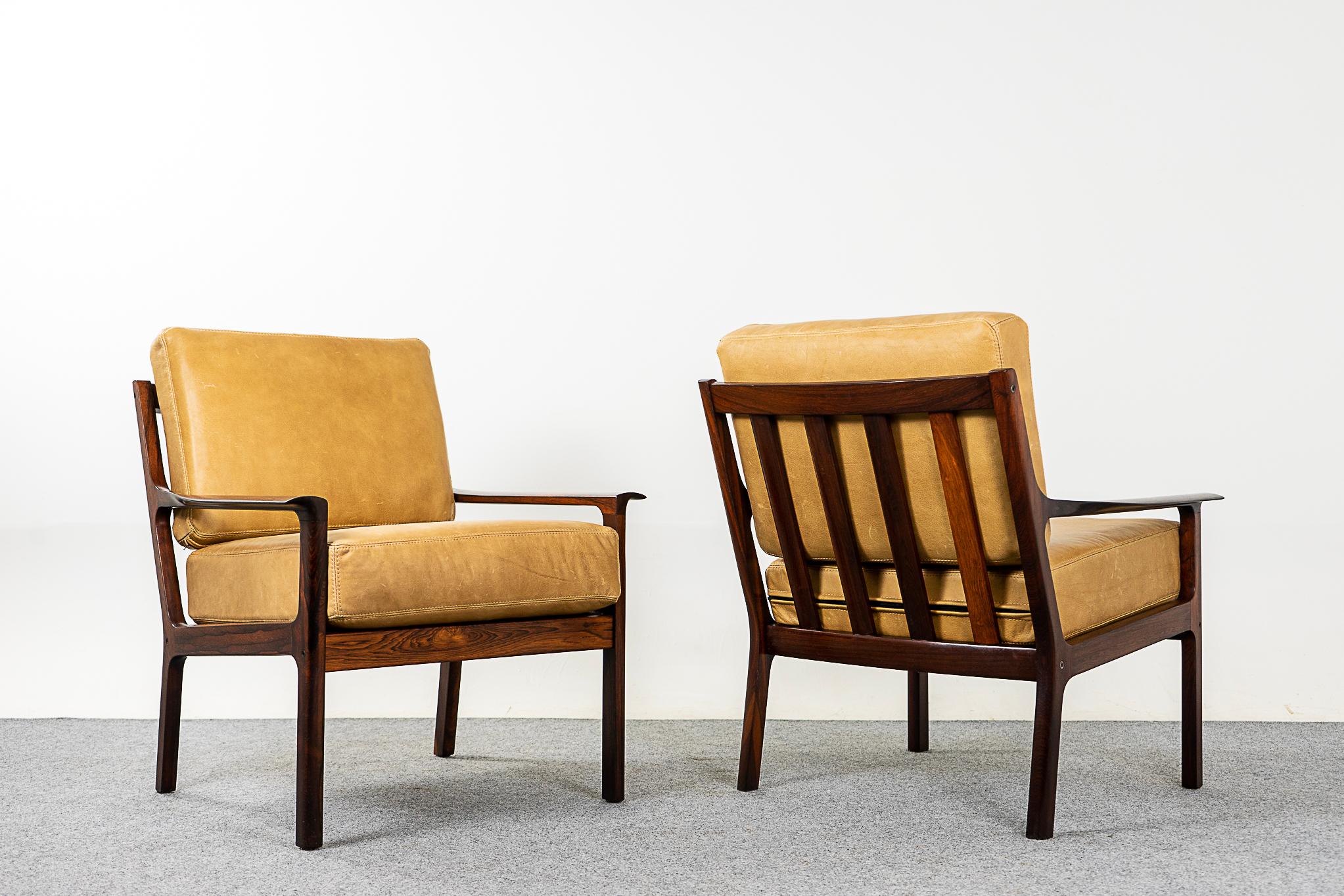 Rosewood & leather Norwegian lounge chair pair by Frederik A. Kayser, circa 1960's. Sculpted solid rosewood frames with stunning, graceful lines and slatted backrest. New buttery soft tan leather contrasts perfectly with frames. Comfortable, supple,