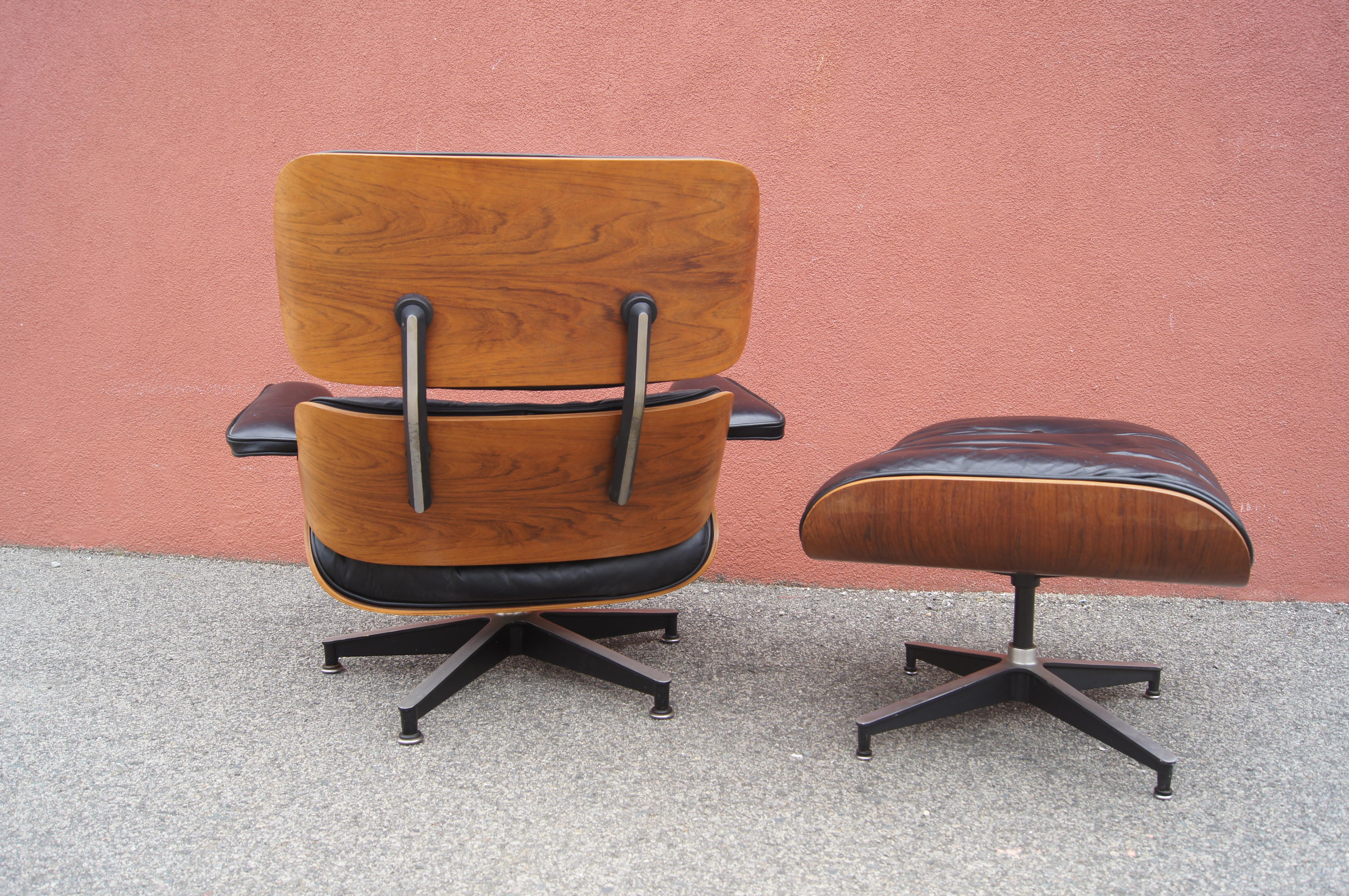 Charles and Ray Eames's classic lounge chair and ottoman for Herman Miller, models 670 and 671, exemplify deep comfort. A shell of molded rosewood veneer rests on a base of black enameled aluminum; the original down-filled cushions are upholstered