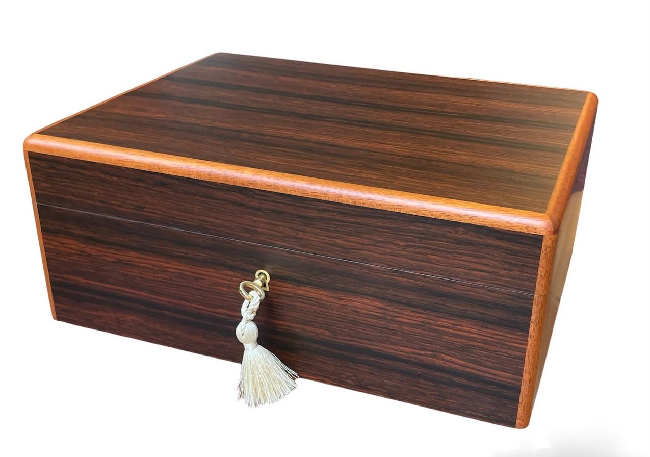 This well figured Rosewood jewellery casket was manufactured by the famed manning of Ireland company and is truly a jewel of handcrafted genius. This box is constructed of the finest woods available and the knowledge and skill of 4 generations of