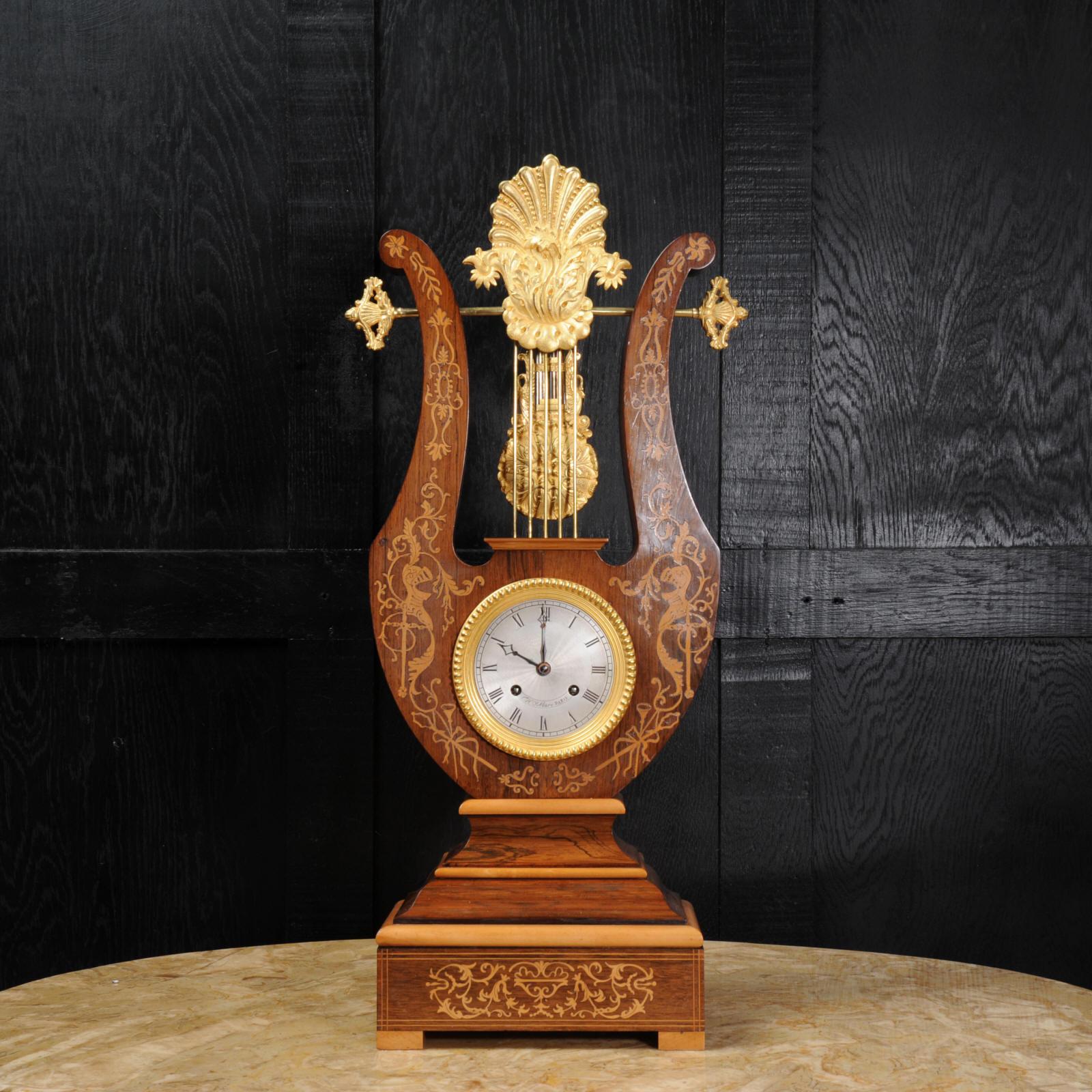 Rosewood and Ormolu Lyre clock with mystery pendulum
French, circa 1850 

Excellent condition, fully overhauled.

An early and stunning clock by Henri Marc of Paris. It is beautifully made in rosewood veneer with delicate marquetry inlay and