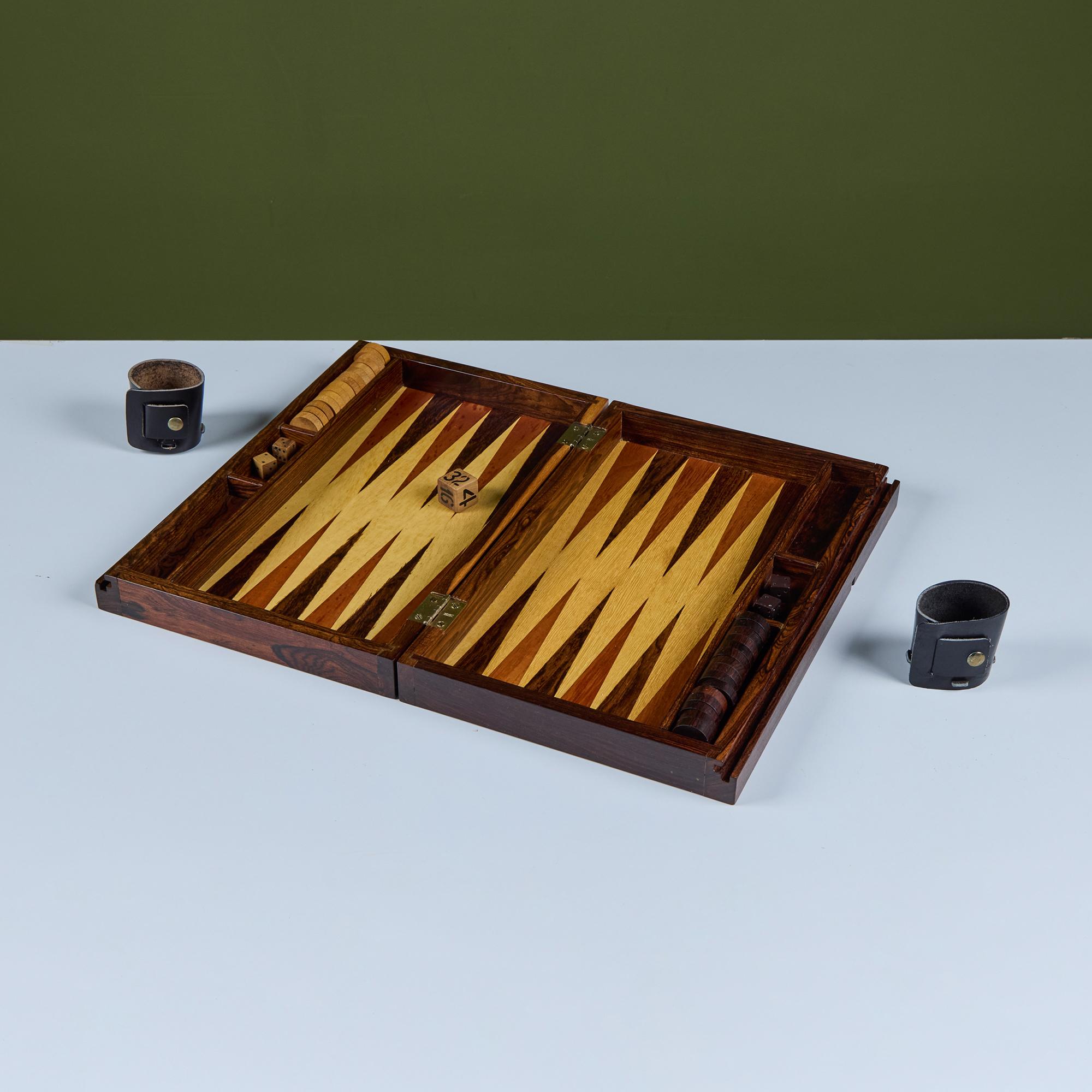 A modernist backgammon set by US-born, Mexico-based designer Don Shoemaker for his company Señal. This portable set includes the game board, which folds up into a carrying case, checkers, rolling dice, doubling dice and leather cups. Made from local