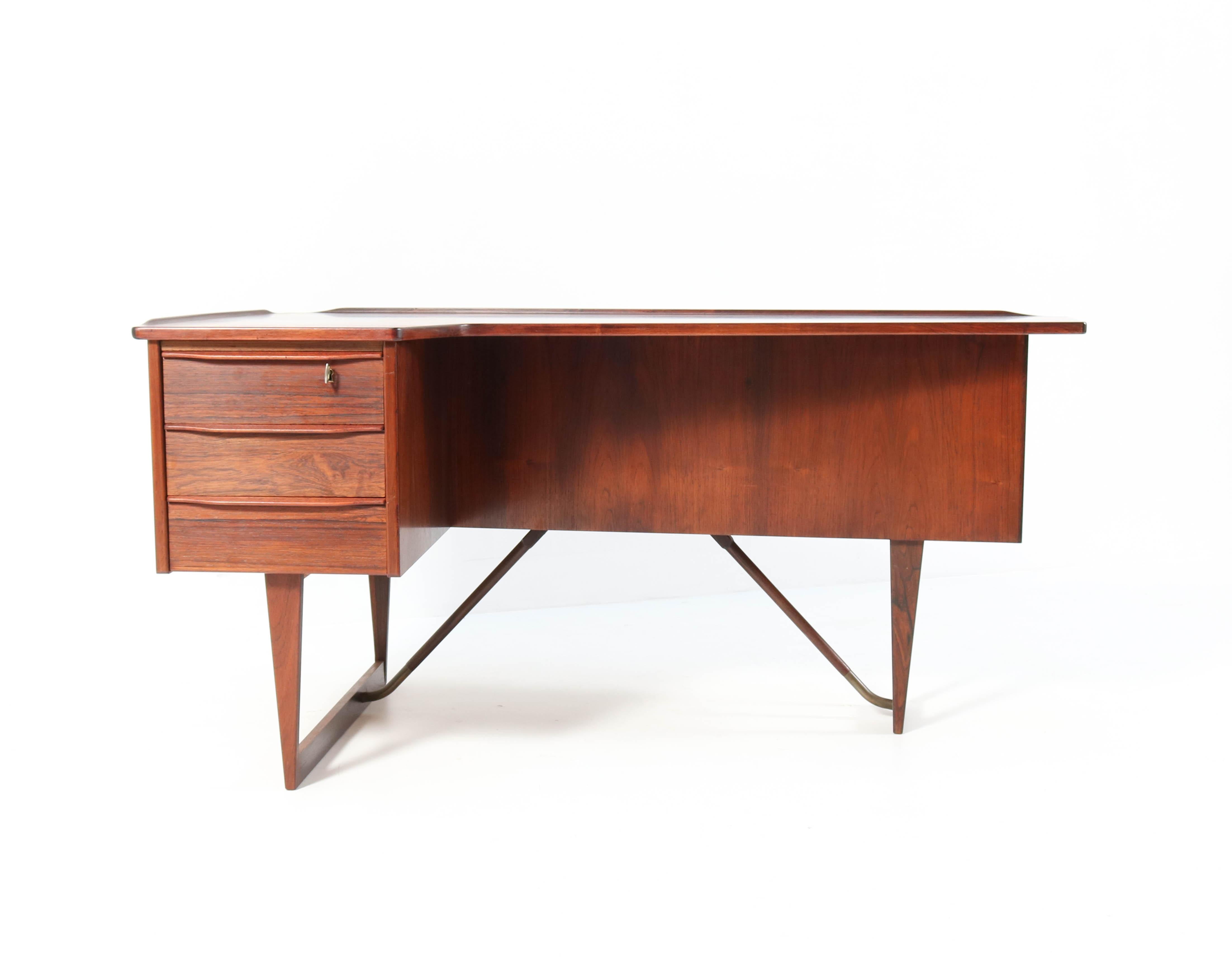 Wonderful shaped Mid-Century Modern boomerang desk.
Design by Peter Løvig Nielsen for Hedensted Møbelfabrik.
Striking Danish design from the fifties.
Solid rosewood and rosewood veneer with a nice warm grain.
This fantastic piece of furniture