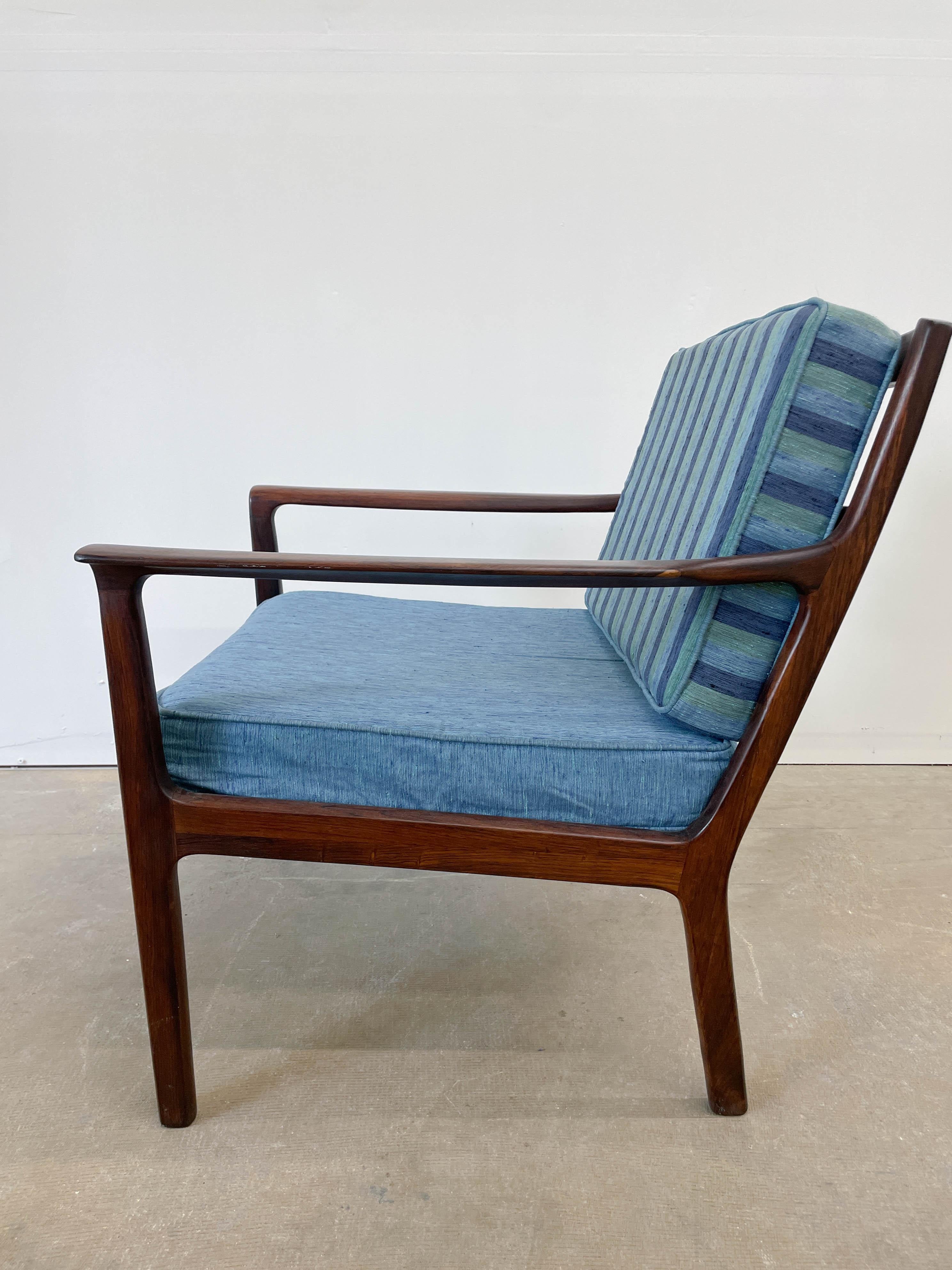 Beautifully crafted from solid Brazilian Rosewood, this Mid-Century Modern lounge chair is clearly heavily influenced by Norwegian designer Fredrik A. Kayser's nearly identical lounge chair. It is believed this chair was made in Sweden in the 1960s,