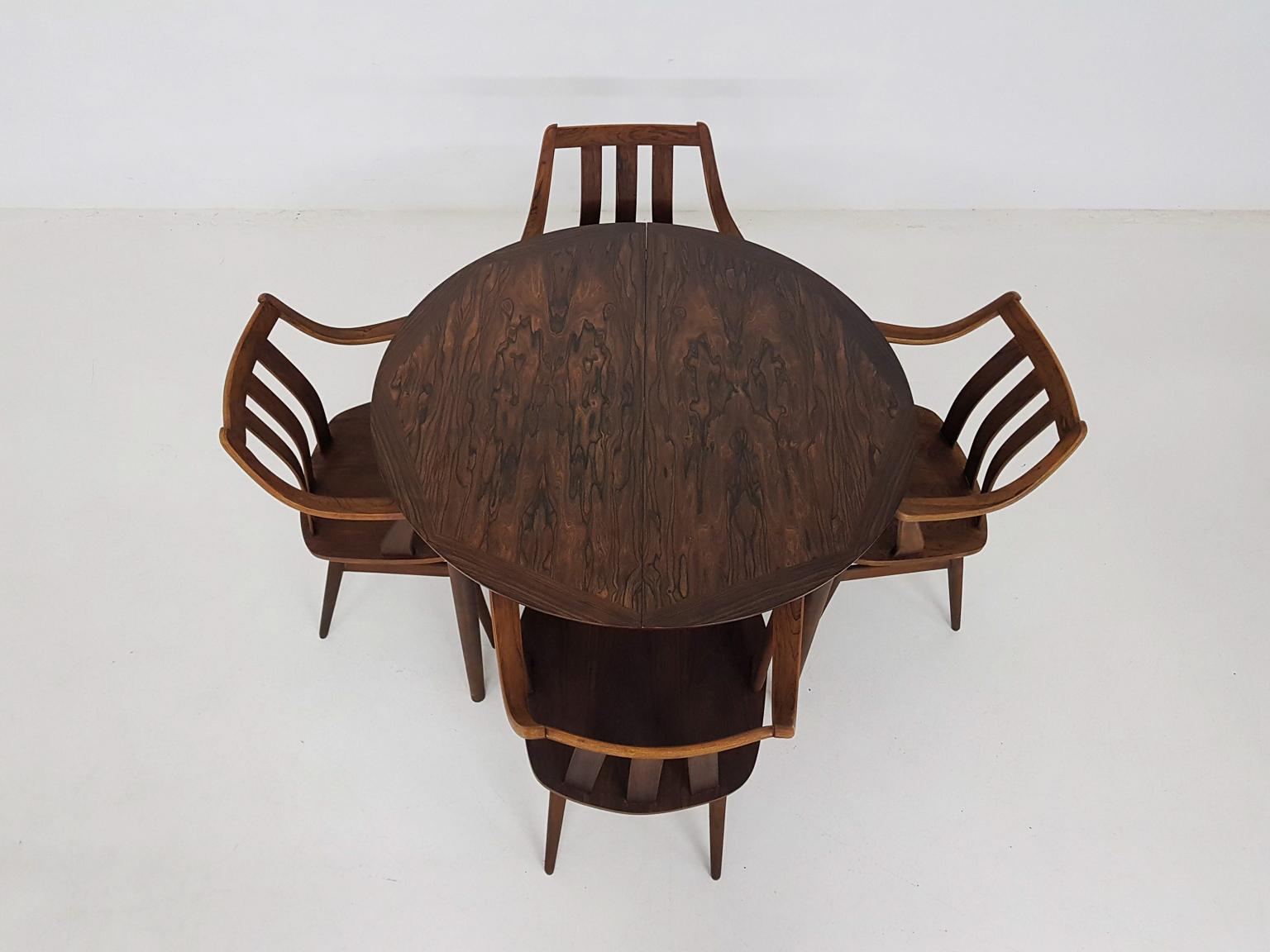 Beautiful midcentury rosewood dining set consisting of a table and four chairs.

The set is made of the best dark rosewood veneer with a beautiful grain to the wood. Chairs have elegant shapes and remind us of Danish design. Table can be extended