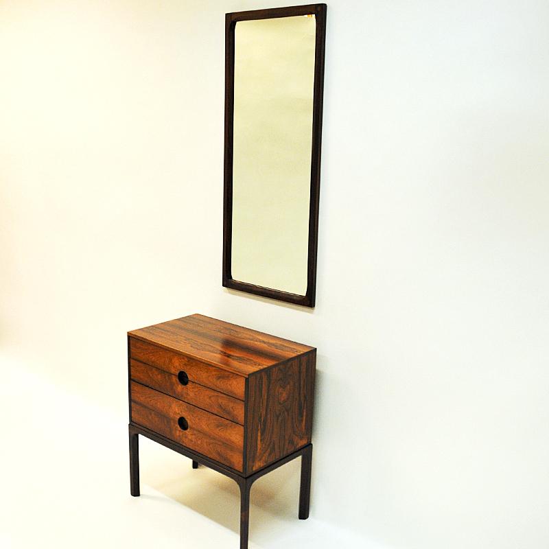 Stunning set 'Chest of drawers and Hall mirror' in rosewood designed by Kai Kristiansen for Aksel Kjersgaard in Odder, Denmark 1950s. The console has three drawers (2 smaller and 1 bigger) with integrated circular handles. Labelled by manufacturer