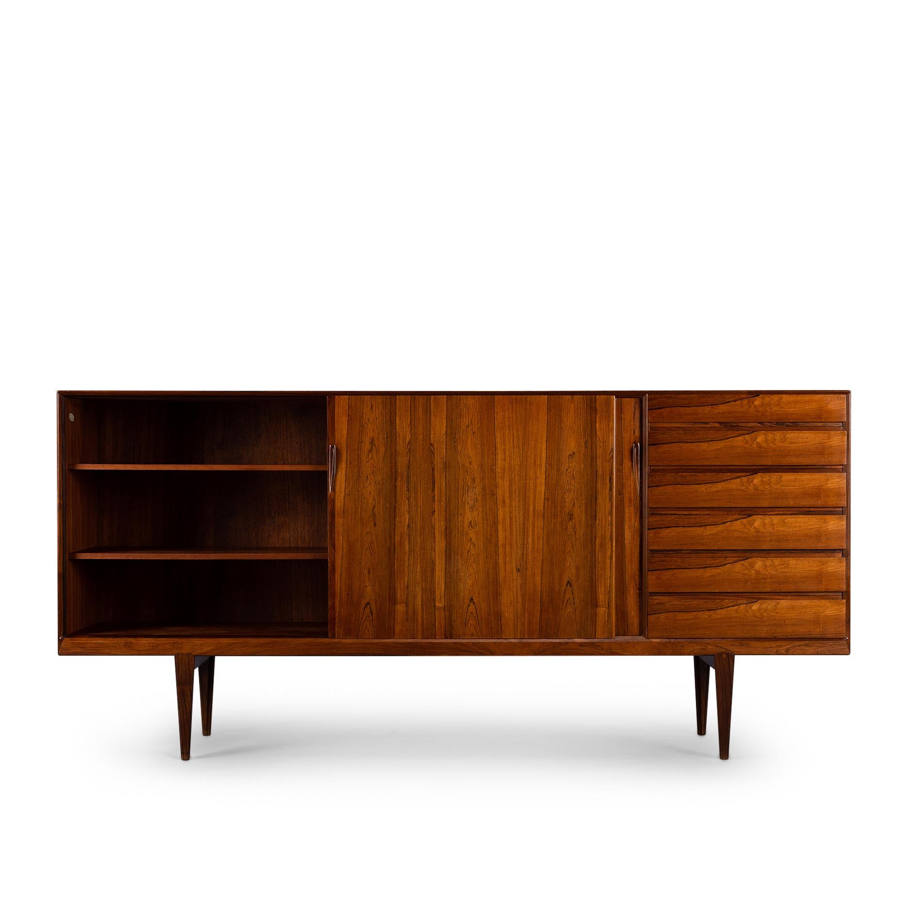This elegantly designed credenza by Henri Rosengren Hansen for Brande Møbler provides for a true storage bonanza in a superb patterned rosewood veneer shell. A righthand console consisting of 6 spaceous drawers with superbly bevelled drawers with