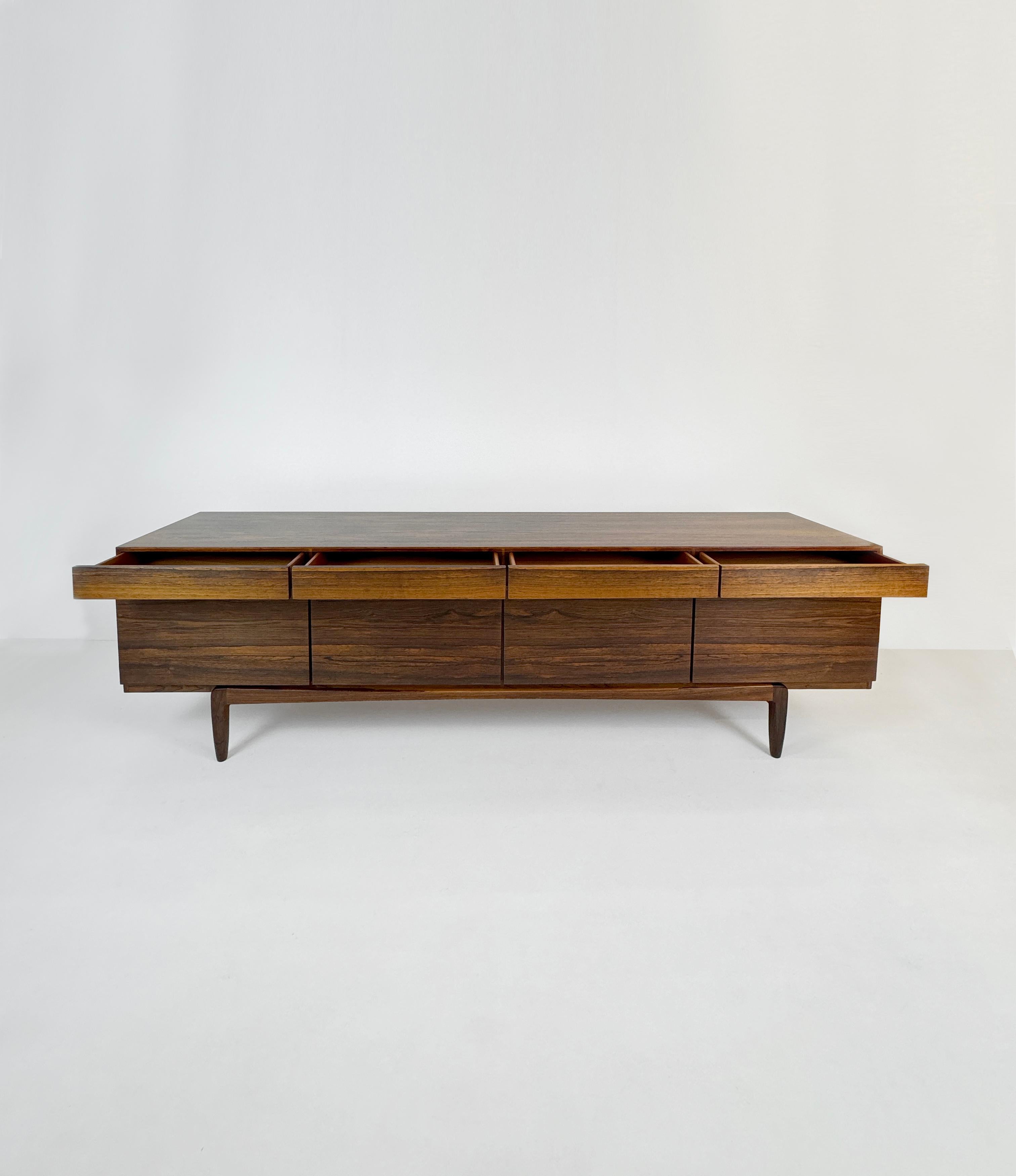 Ce remarquable buffet en bois de rose modèle FA66 a été conçu par Ib Kofod-Larsen pour Faarup Møbelfabrik dans les années 1960. Ce buffet moderne danois est fabriqué en magnifique palissandre brésilien d'une teinte riche, avec de magnifiques