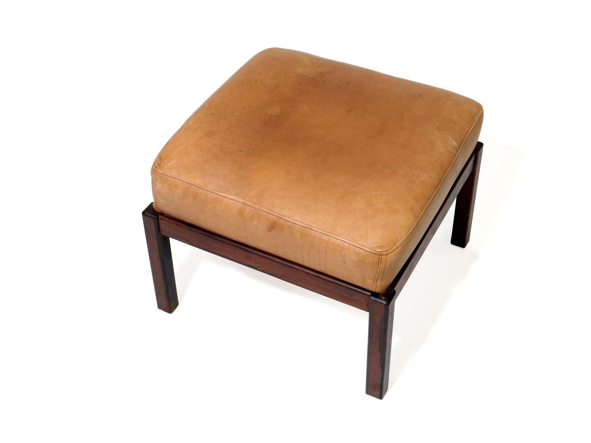 Mid-century ottoman crafted of a solid Brazilian rosewood frame upholstered in the original saddle leather.
  