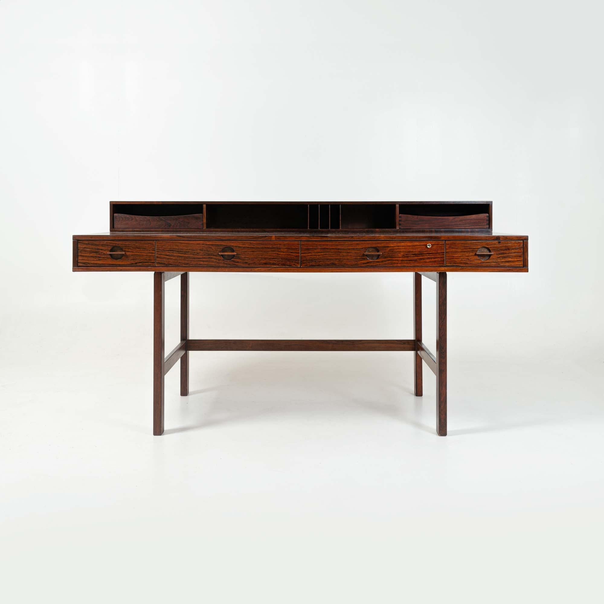 Extremely rare Flip top partner's desk by Peter Lovig Nielsen in rosewood with brass fittings. Retains original trays for the upper level cubbies. The top shelf of the desk flips down to extend the work surface allowing it to be used as a partner’s