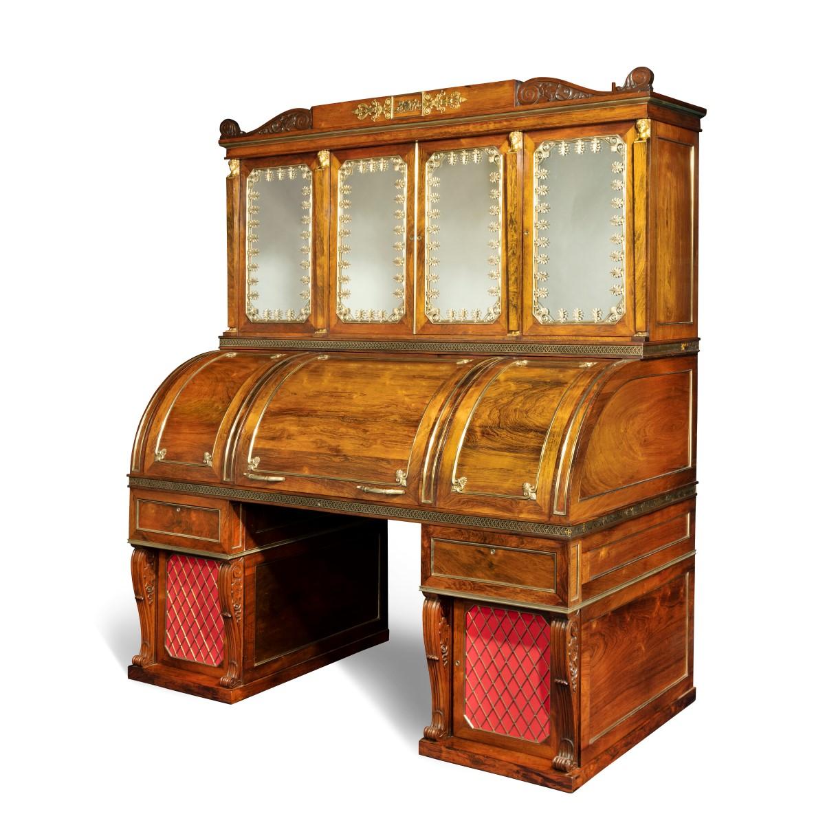An impressive and monumental rosewood Regency kneehole bureau cabinet with ormolu mounts of exceptional quality, attributed to Seddon and Morel, the central roll-top opening to reveal a fitted secretaire in satinwood with a sliding leather-inset
