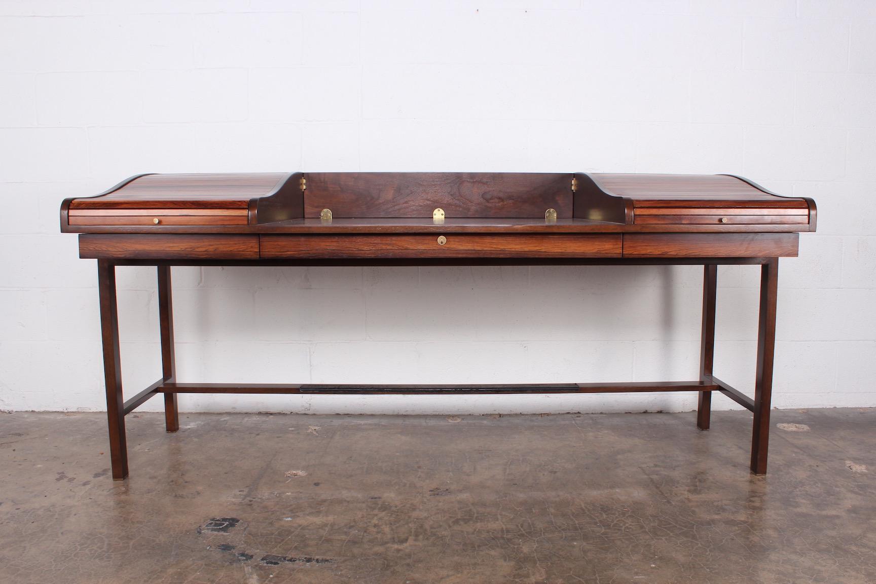 A rosewood tambour roll top desk with brass feet and leather trim. Designed by Edward Wormley for Dunbar.
 