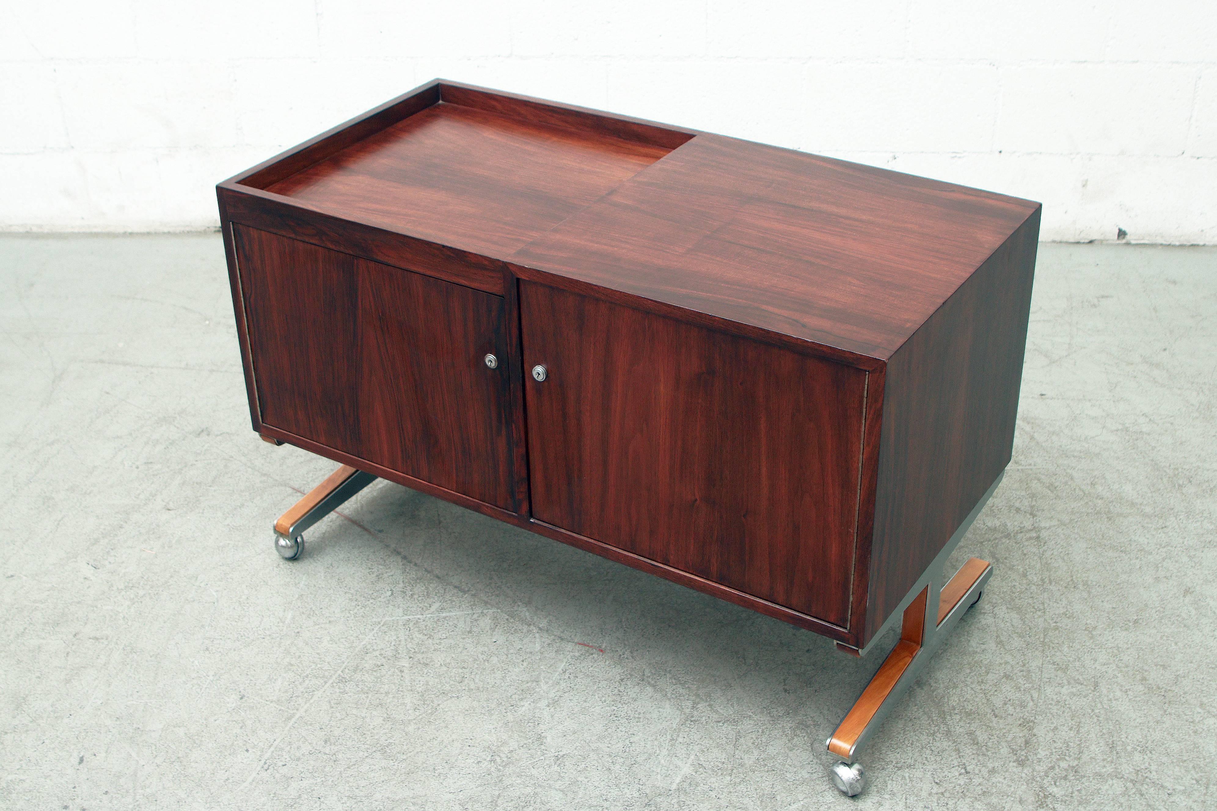 Beautiful lightly refinished rosewood cabinet with room for a turn table on top and record storage and two key-lock cabinets. Contrasting wood on feet. In good original condition with some wear consistent with its age and usage.