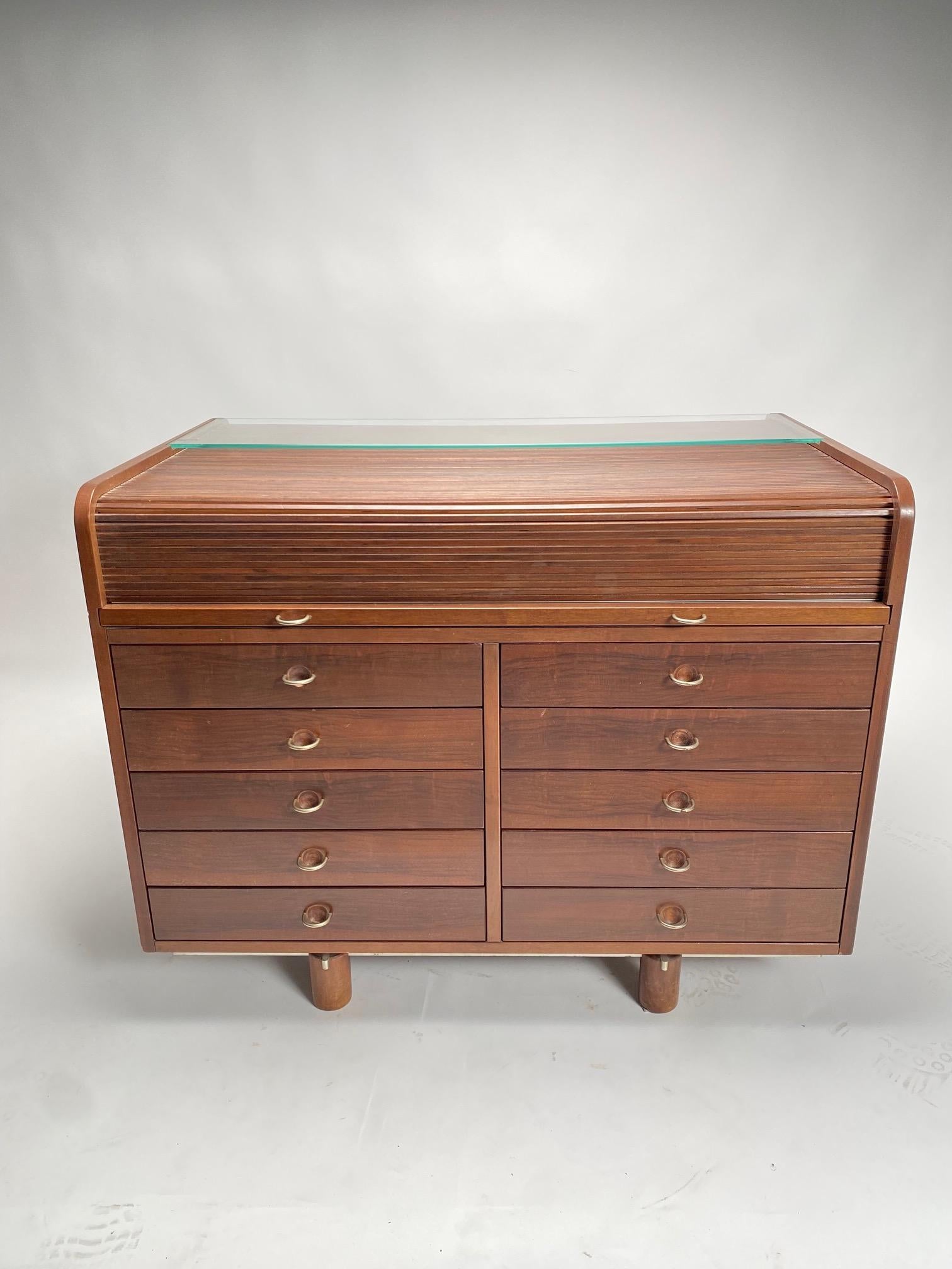 Gianfranco Frattini designed this gorgeous rosewood rolltop desk, model 804, for Bernini in the early 1960s. What appears to be a compact chest of ten drawers with chrome pulls transforms into a desk when the concealed leather-covered top is pulled
