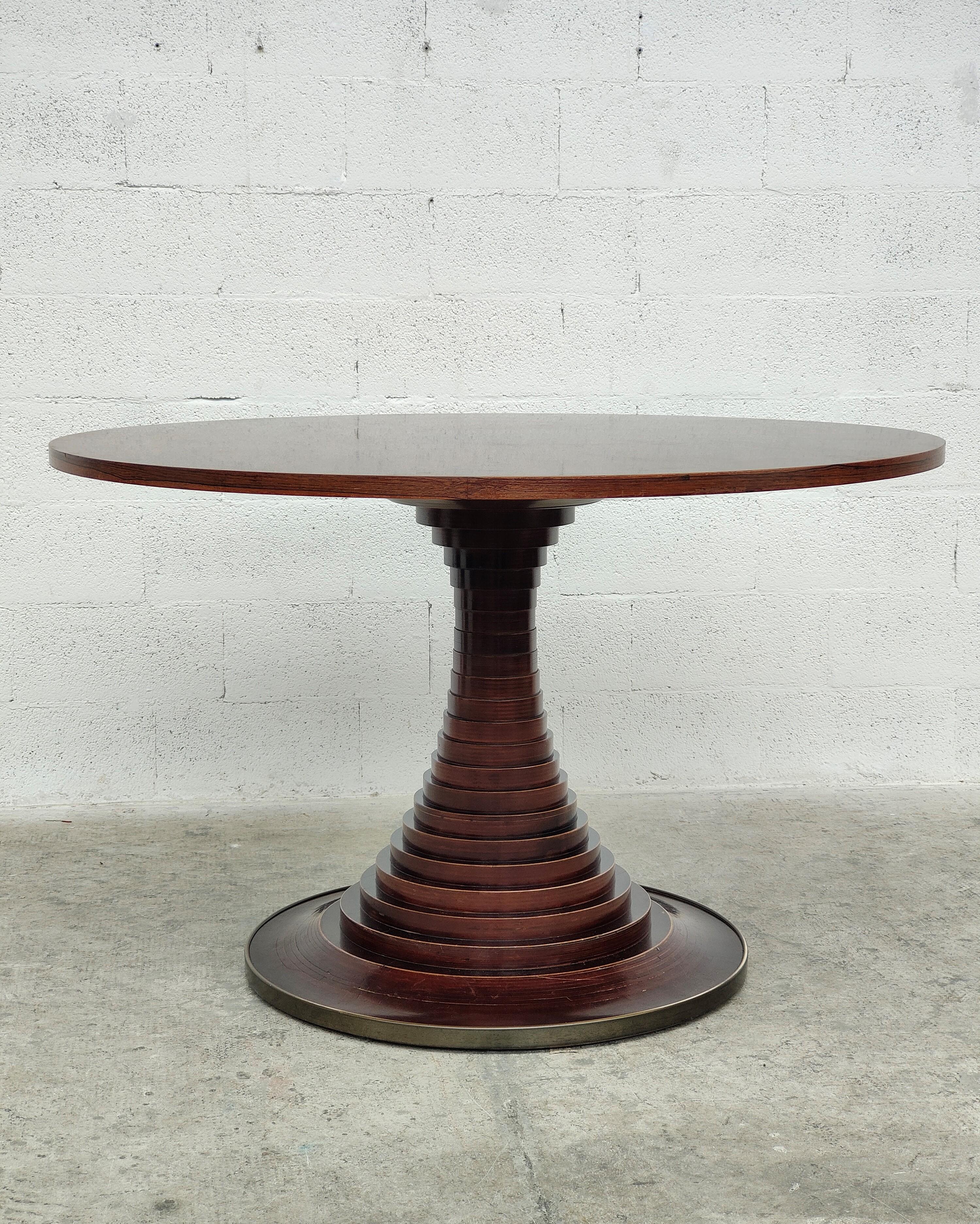 Wooden  circular dining table designed by Carlo de Carli for Sormani 1960s.
The beautiful top stands on a striking base made of solid wooden discs, with a circular brass trim detail. 
Dimensions: diameter 125 cm - height 78 cm.
 