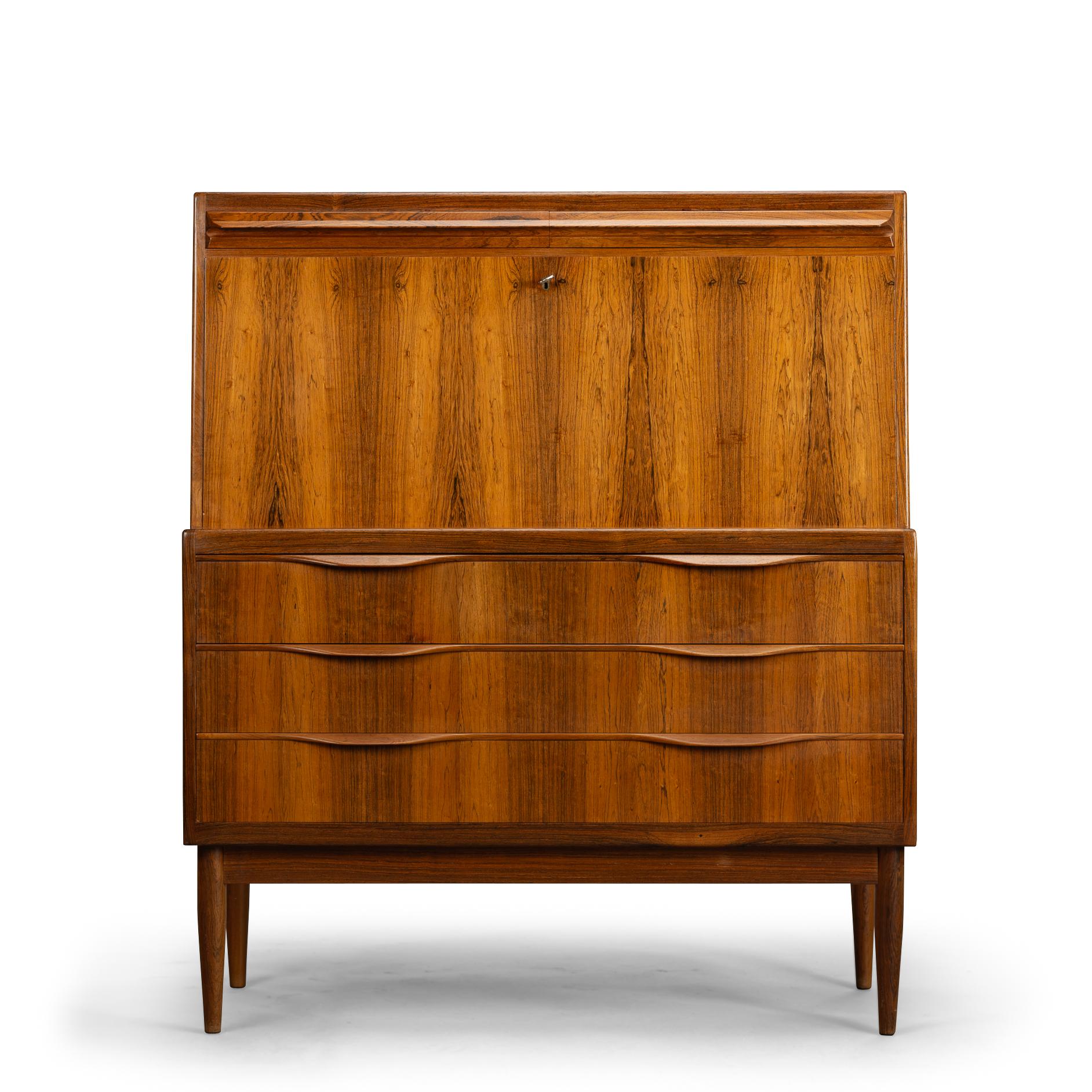 Danish Design
Danish rosewood secretary designed by Erling Torvits for Klim Møbelfabrik. This secretary has a hinged leaf that drops down and becomes a sturdy desktop. Behind this leaf are three drawers. Above this there are two compartments that