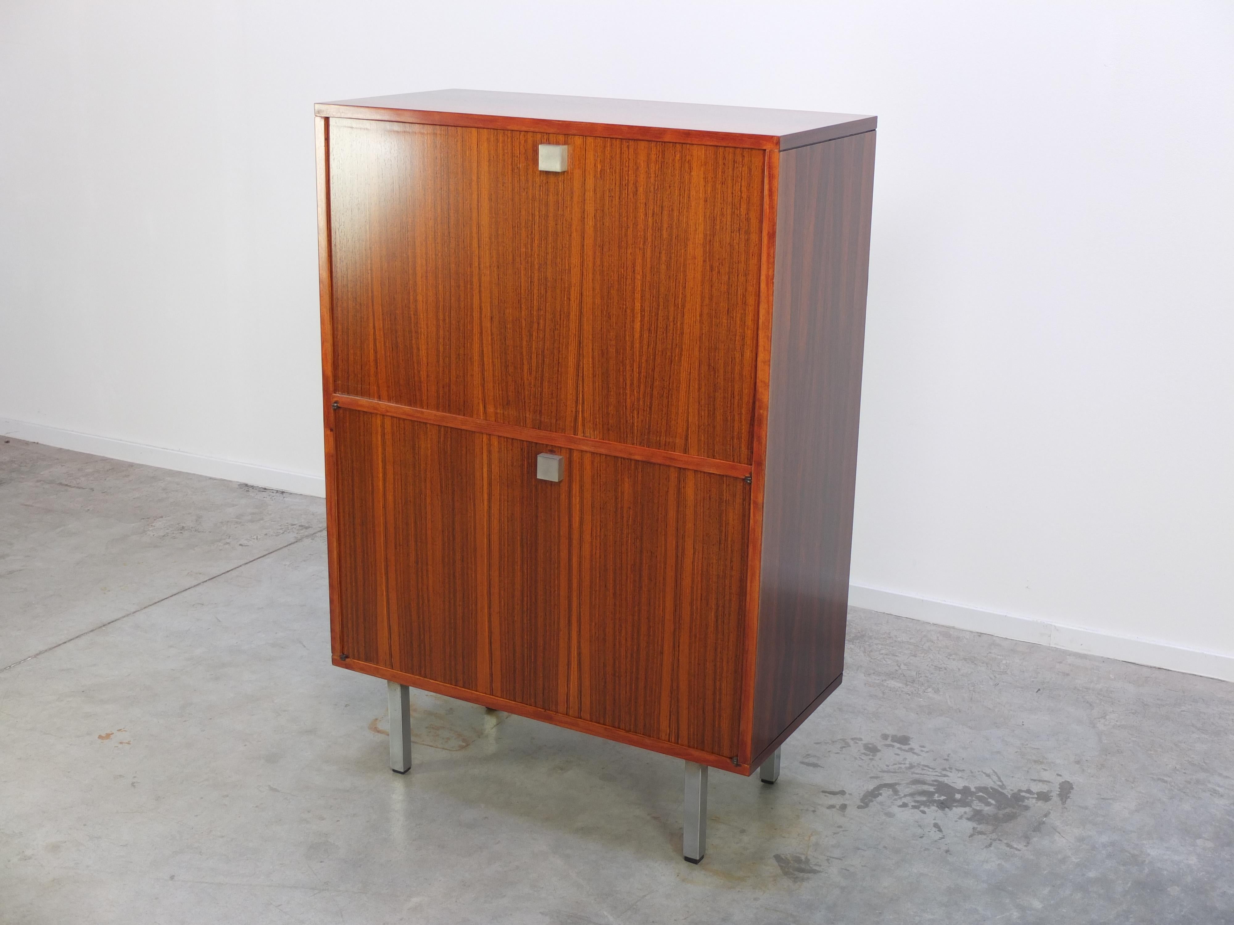 Lovely secretary cabinet by Belgian modernist designer Alfred Hendrickx for Belform, 1960s. Made of Brazilian Rosewood with a fantastic decorative woodgrain and metal feet. The large door opens a work top with storage compartment and three neatly