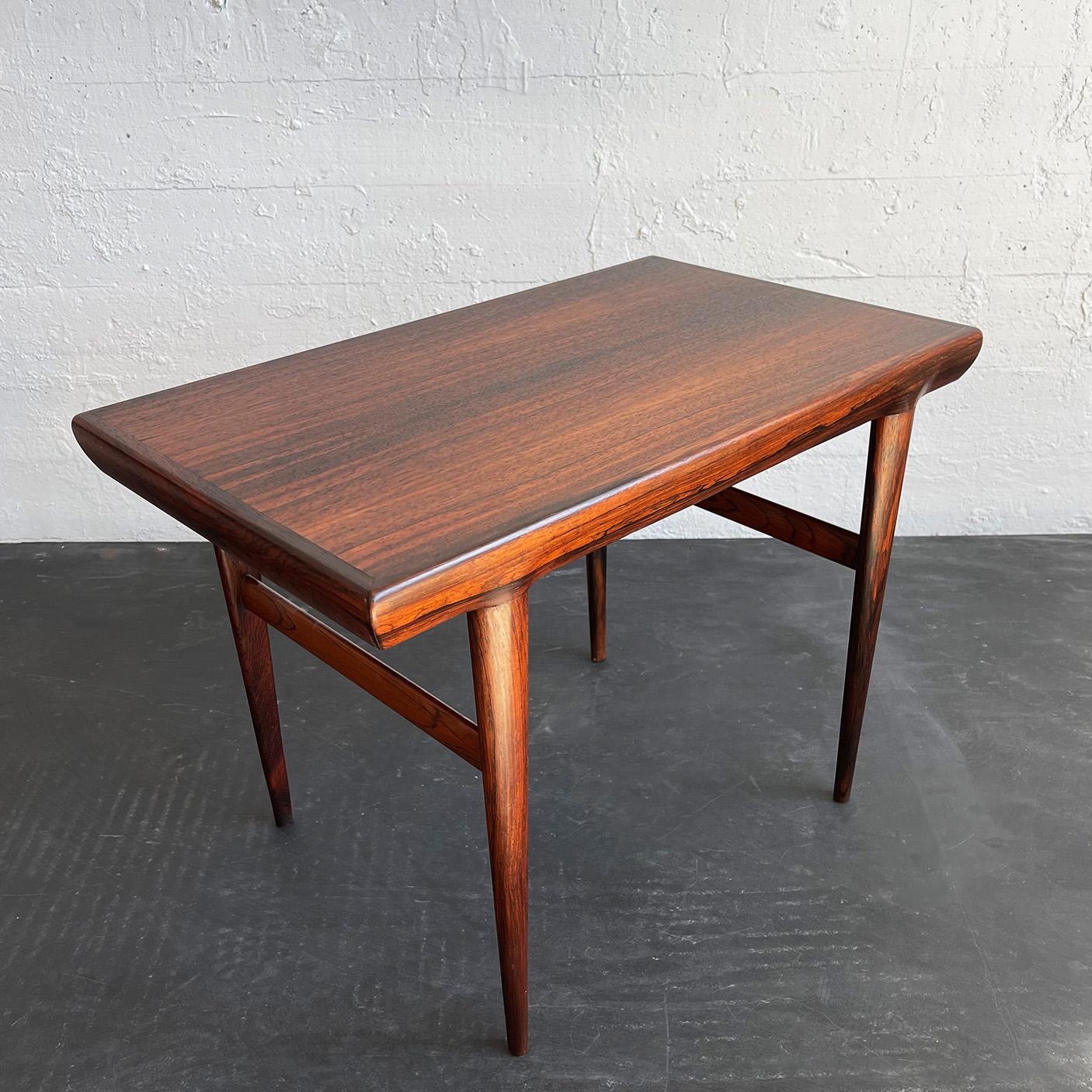 Elegant, Scandinvian modern, Brazilian rosewood, side table designed by Johannes Andersen for CFC Silkeborg, Denmark features a rounded, organic profile with slender tapered legs. 