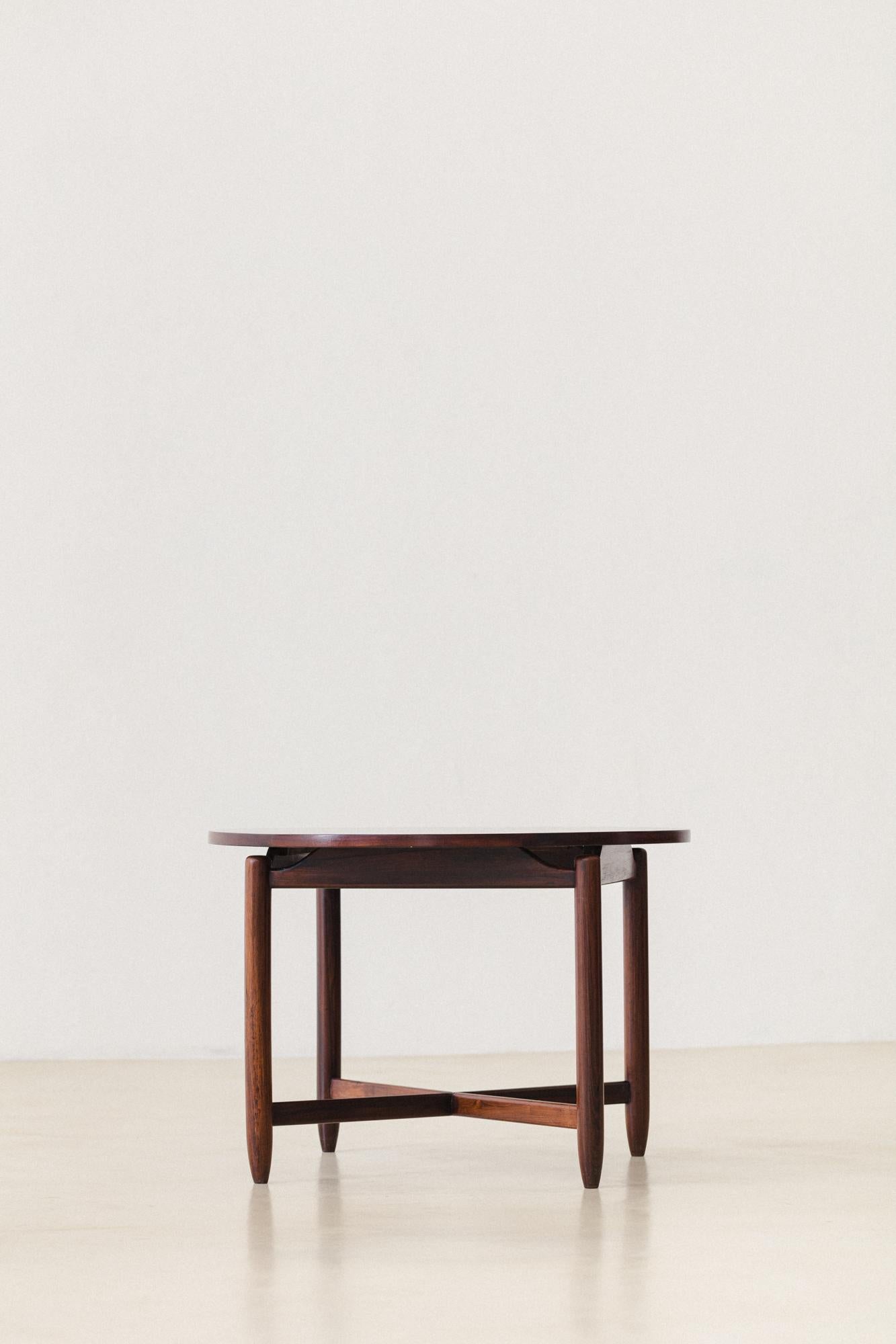 This Side Table was produced by Cantù Móveis e Interiores Ltda. in the 1960s. The piece is made of a solid Rosewood structure with a round veneered top. The simple design is highlighted by beautiful details: the legs don't touch the tops and are fit