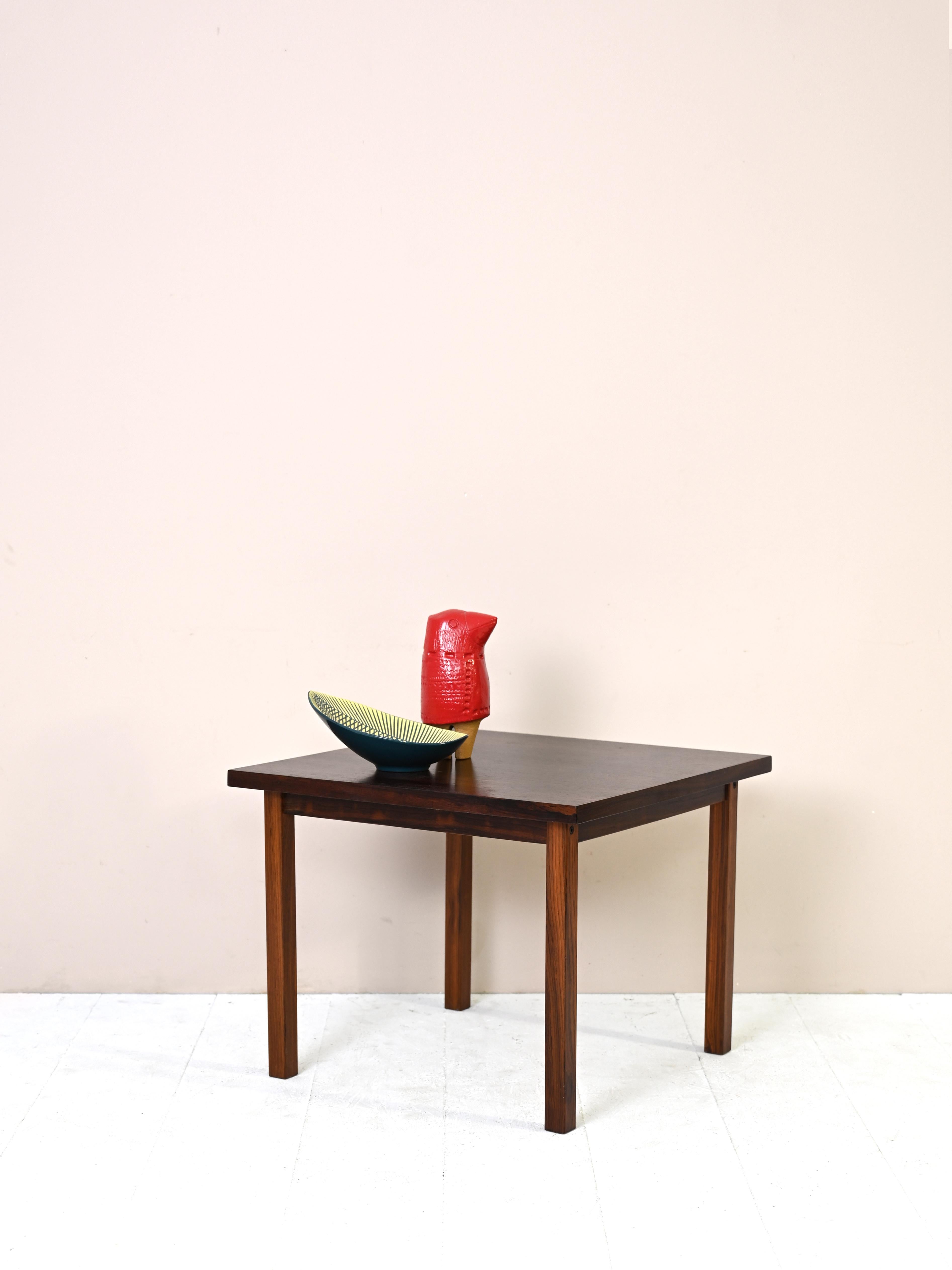 Table scandinave vintage aux formes simples et minimalistes.
Il présente un plateau carré où ressortent les veines prononcées du bois de palissandre.
Élégant et d'une beauté intemporelle.

Bon état. Une restauration conservatrice avec des