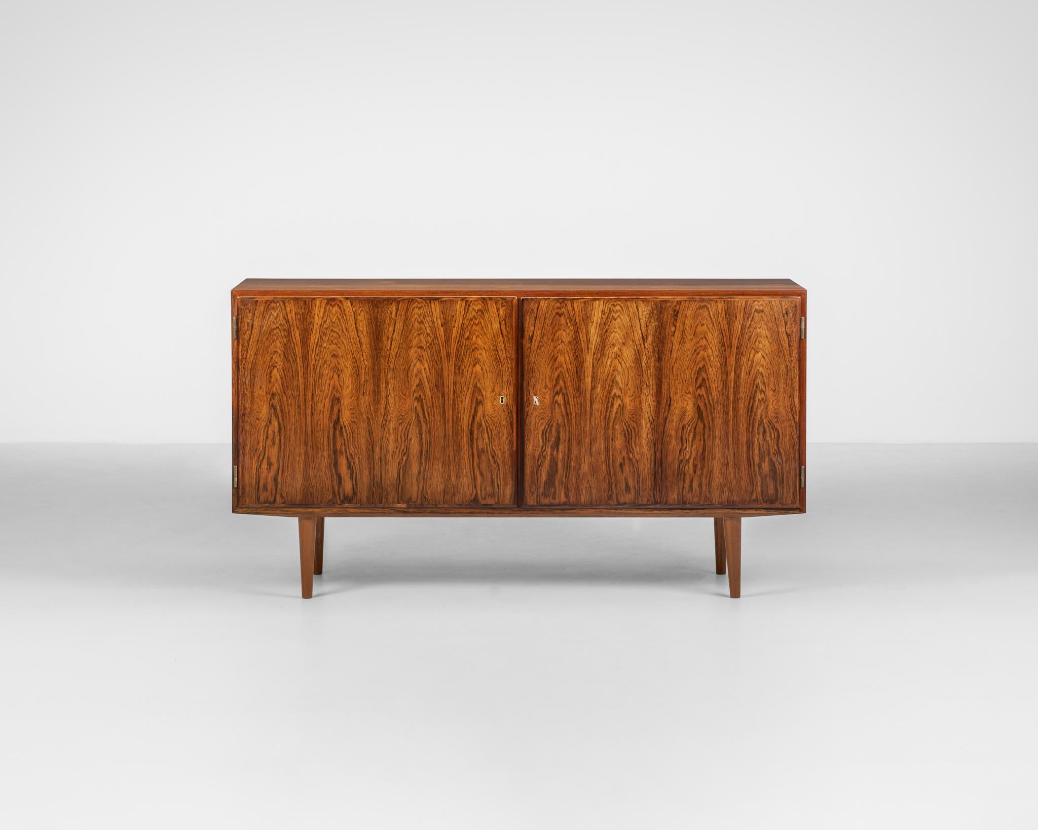 Beautiful and Finely crafted Midcentury Danish Modern rosewood Sideboard / Credenza designed by Carlo Jensen and Produced by Poul Hundevad in Denmark c1960. 

Front with two doors and two compartments within the cabinet. On the left compartments