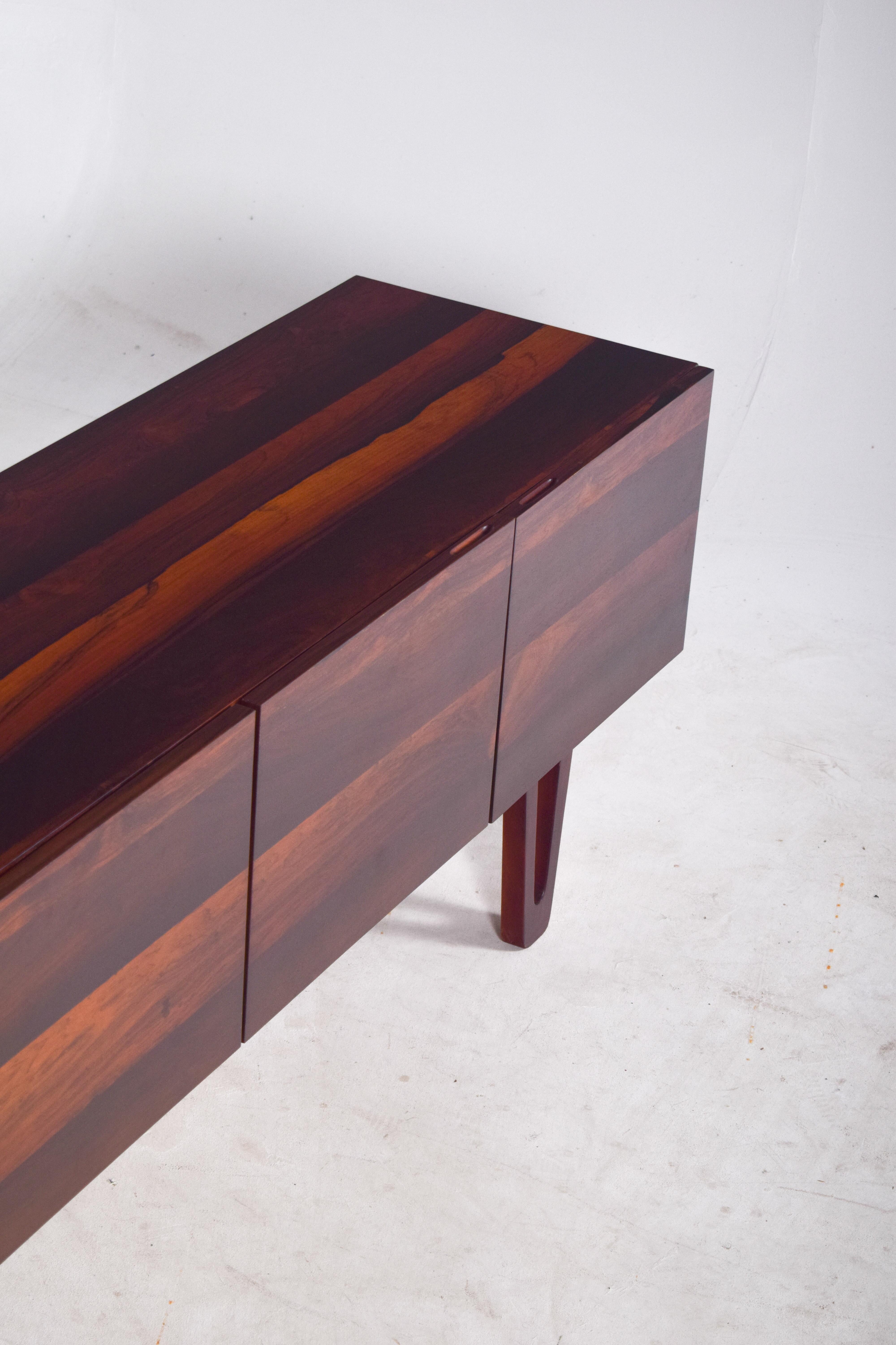 Ce magnifique buffet en bois de rose, fabriqué par Dustwood Portugal en 2025, est une pièce en édition limitée, faisant partie d'une série exclusive de sept exemplaires seulement. Conçu avec un grand souci du détail, le buffet présente un placage de